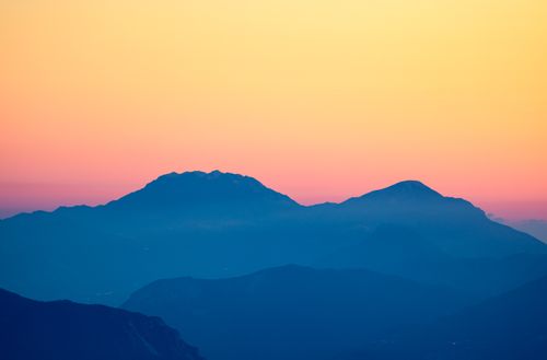 Free Beautiful alpine landscape with mountain silhouettes at sunset, featuring vivid colors and serene natural beauty. Stock Photo