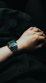 A close-up view of a person's hand wearing a digital watch, showing modern style and functionality.