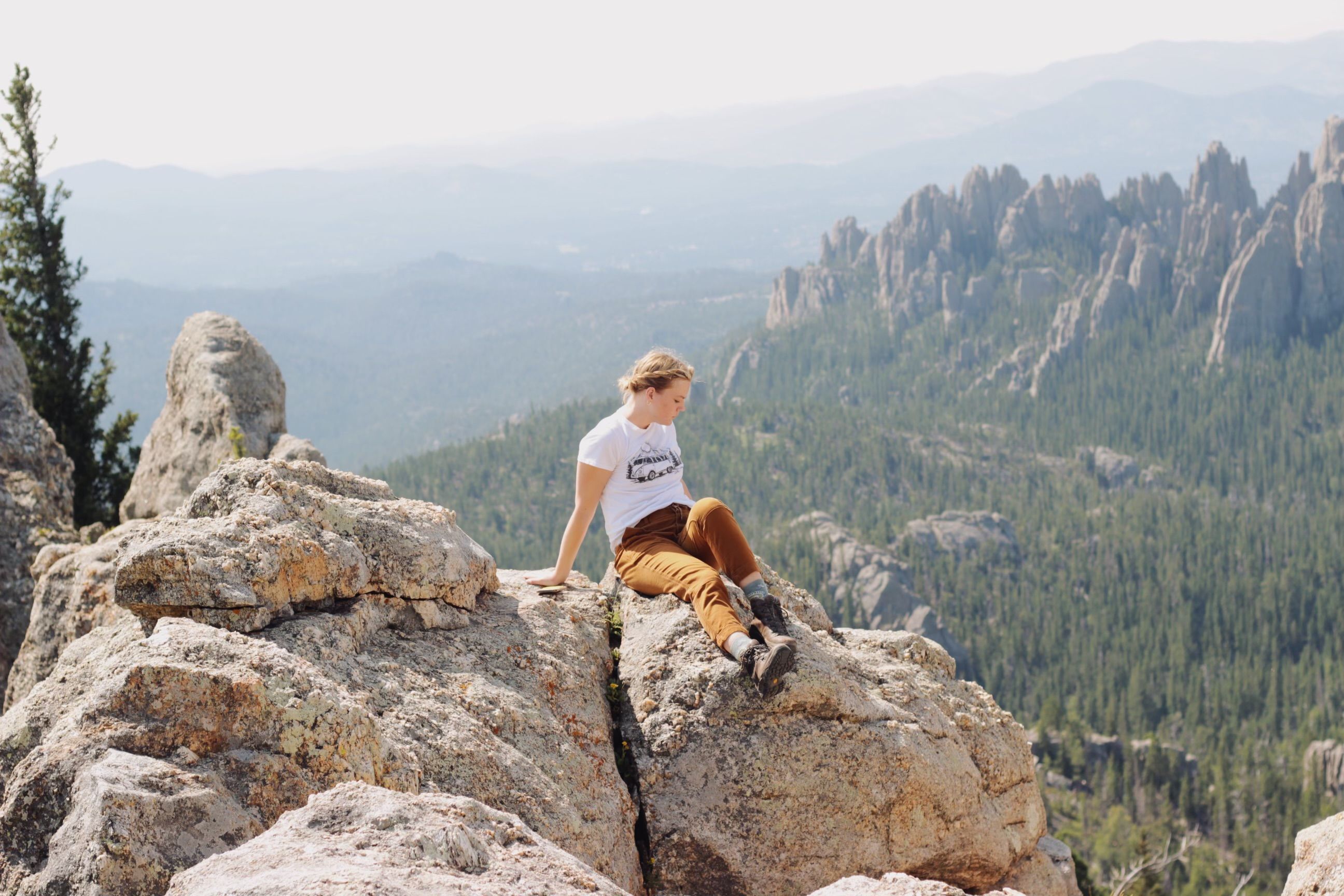 Woman Sitting on Rocky Cliff in Scenic Mountain View · Free Stock Photo