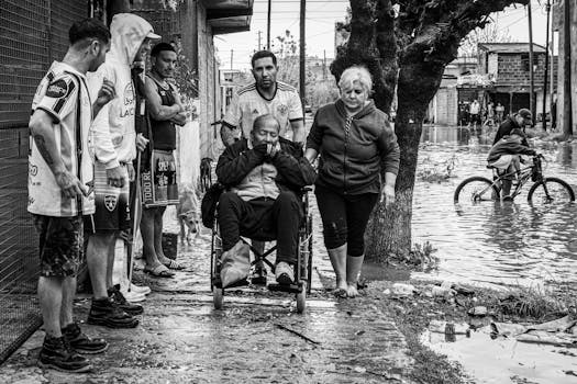 Residents assist an elderly man in a wheelchair through flooded streets in Buenos Aires, Argentina.
