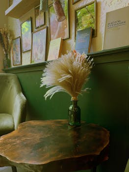 Warm and inviting living space with vase of dried flowers on a wooden table.