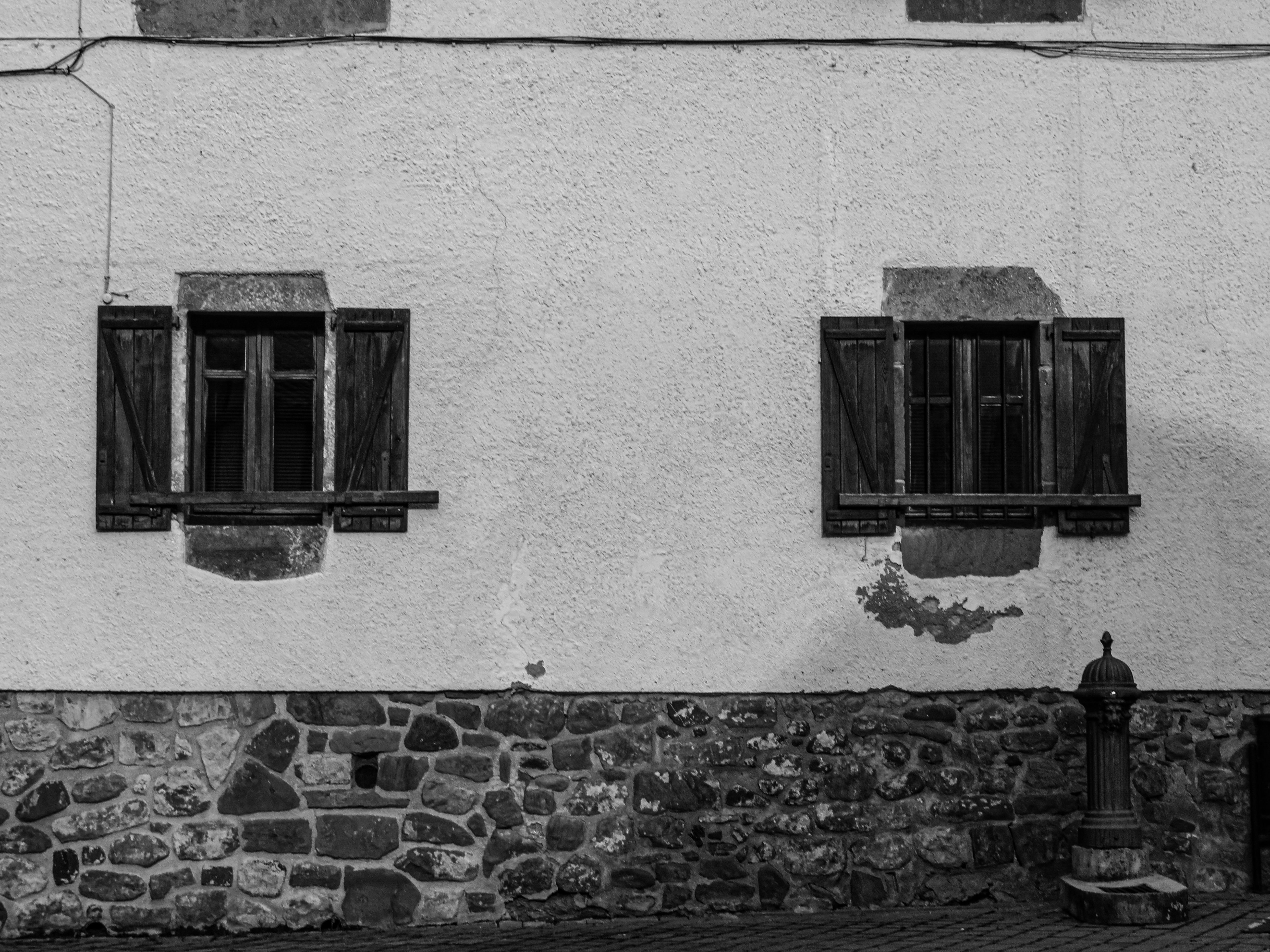 Rustic Stone Wall with Wooden Window Shutters · Free Stock Photo