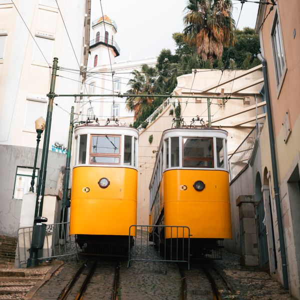Yellow funicular trams on a steep Lisbon street — photo by Emre Bilgiç on Pexels