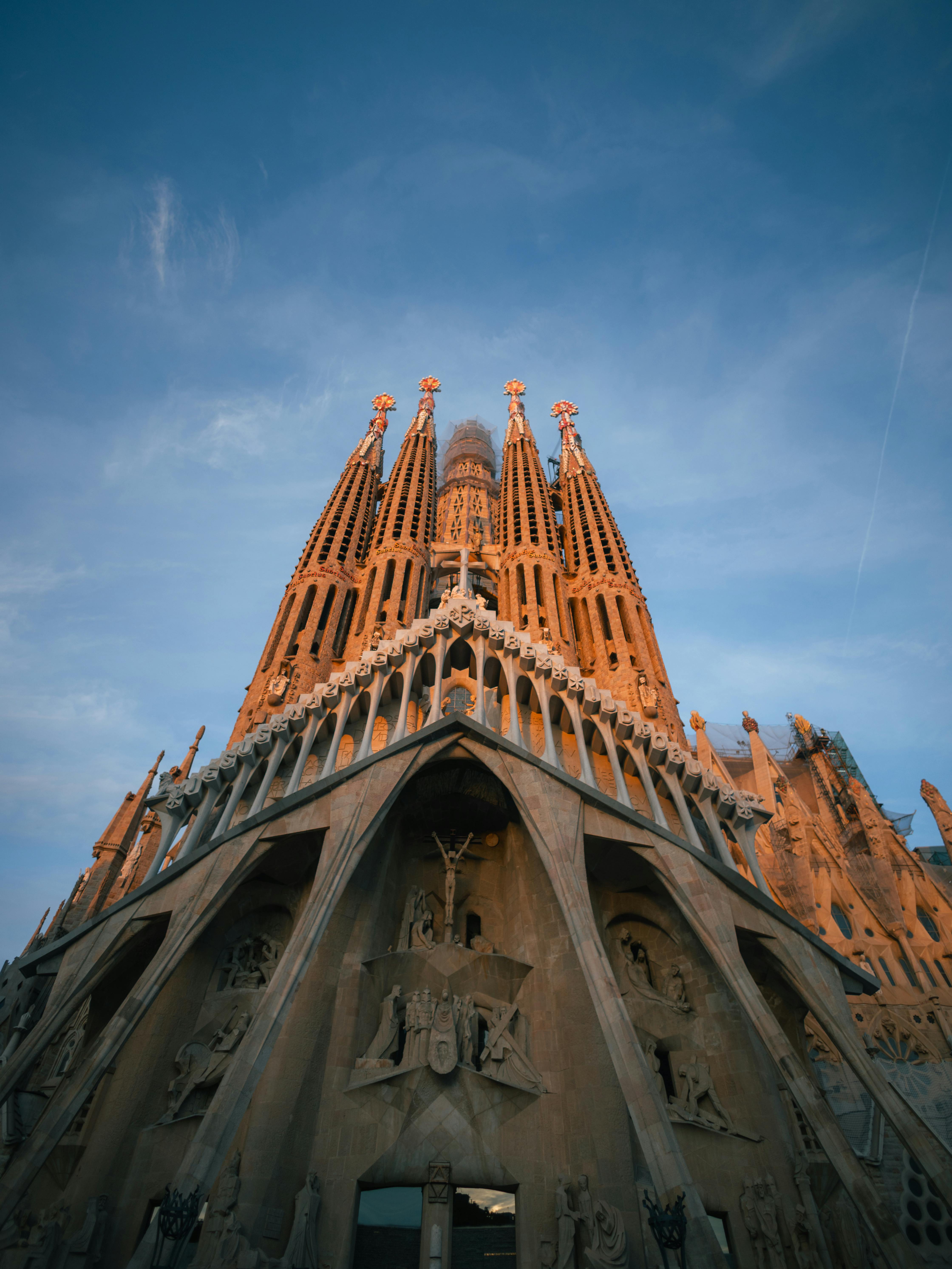 無料 バルセロナのサグラダ・ファミリアの正面に太陽の光が暖かい輝きを放つ雄大な眺め。 写真素材
