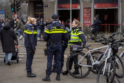 Free Police officers on duty in a busy urban street, interacting with bicyclists. Stock Photo