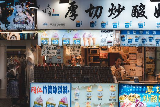 Colorful ice cream shop in Guilin, China, offering various flavors with lively staff and decor.