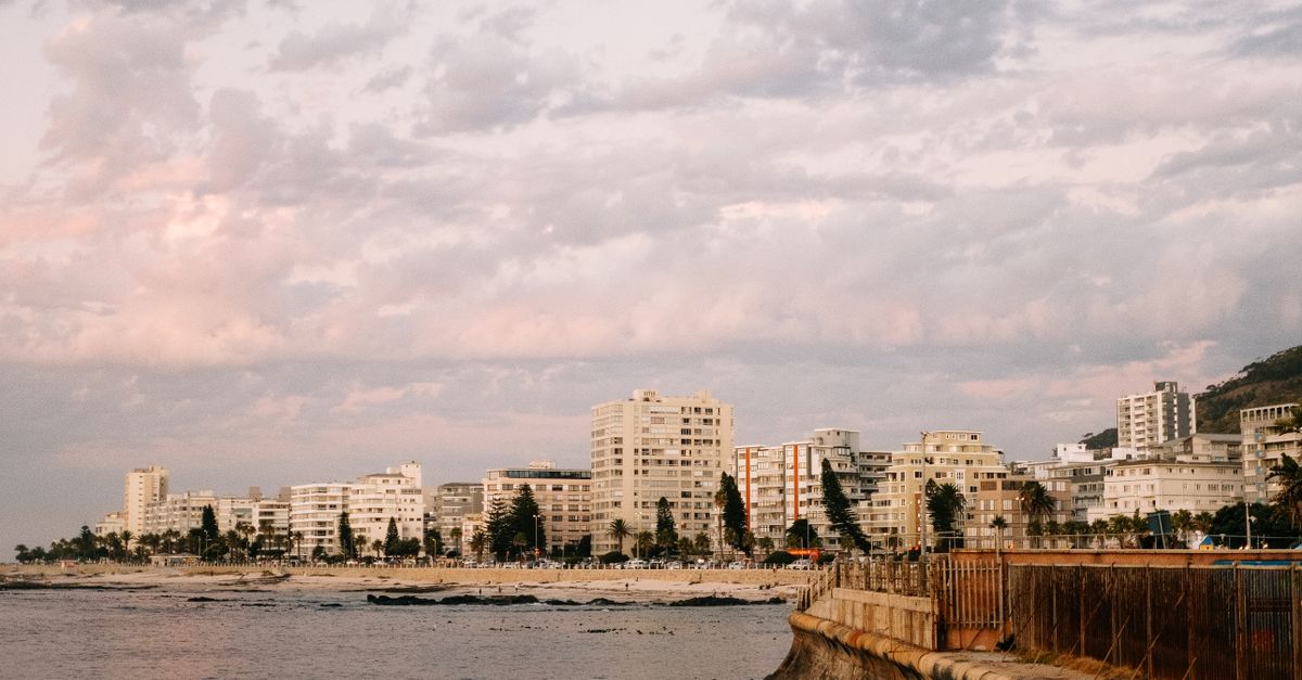 Elegant view of Cape Town's coastline and buildings under a pastel sunset sky.