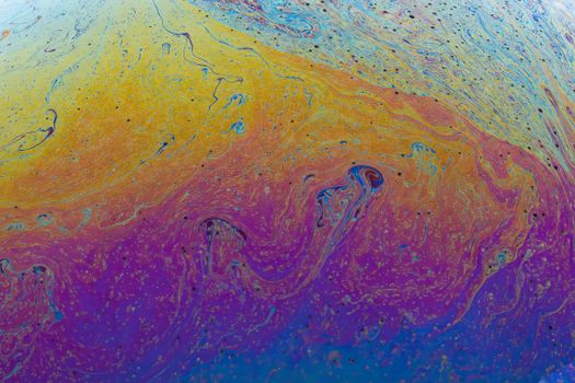 Colorful abstract fluid pattern with vibrant swirling textures and rainbow effect.
