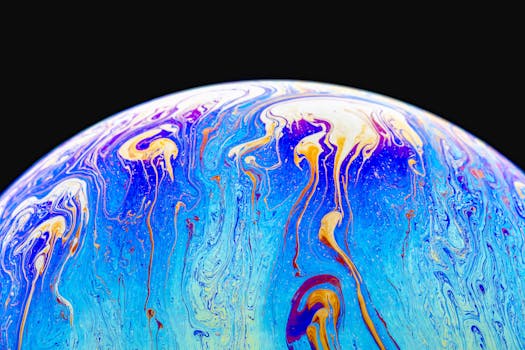 Colorful macro shot of a soap bubble showcasing iridescent textures and vibrant, flowing patterns.