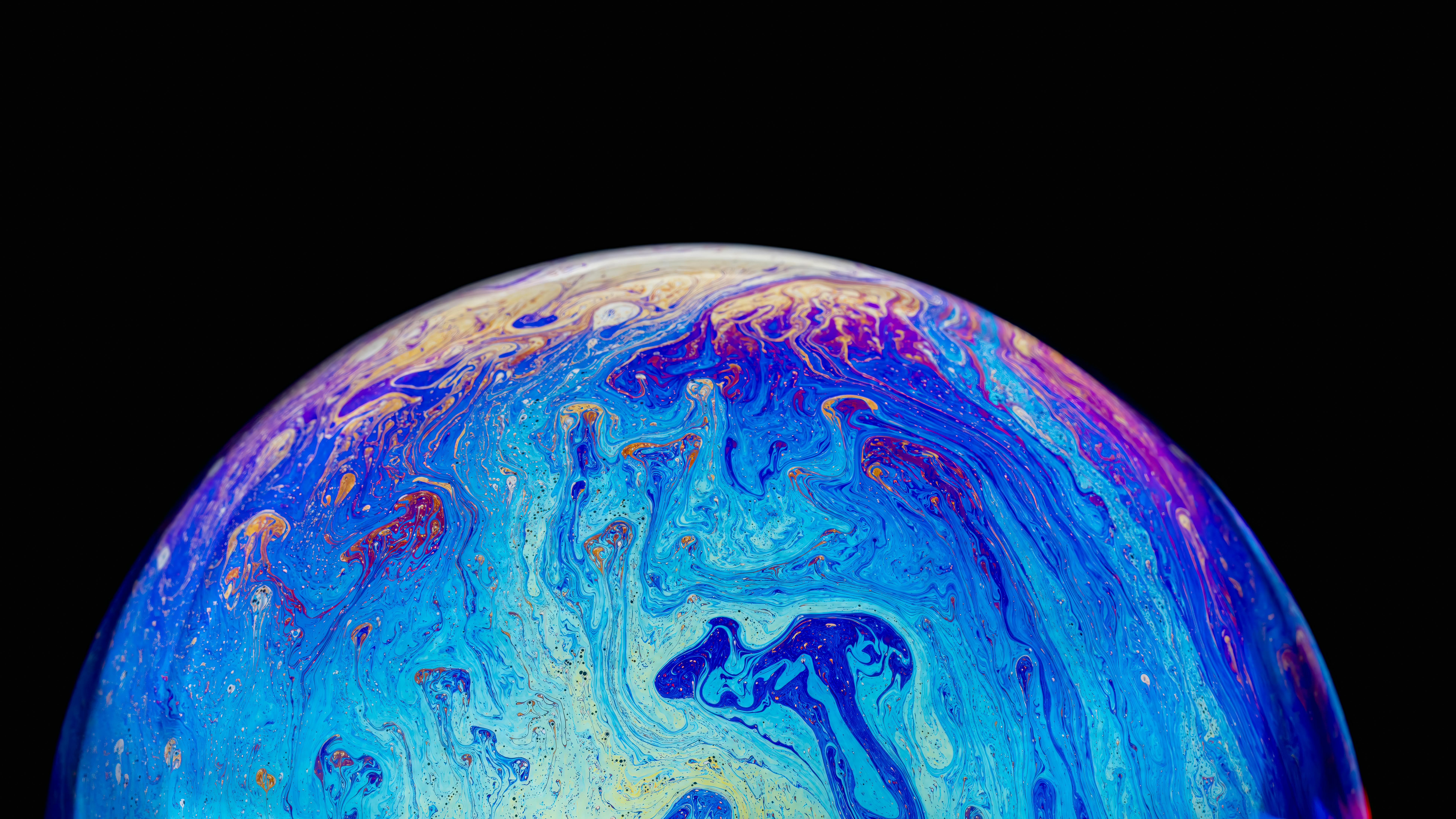 Free Colorful iridescent soap bubble with a psychedelic pattern against a black background. Stock Photo