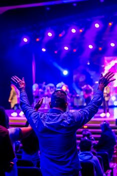 A person enjoying a live concert with vibrant stage lights.