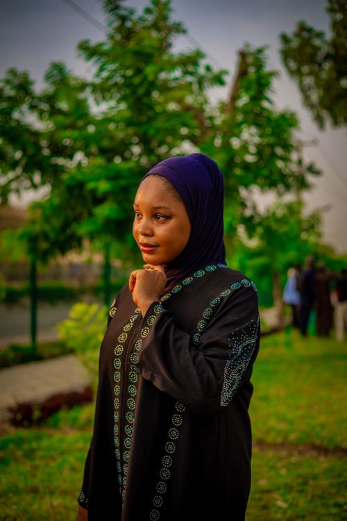 Free Elegant portrait of woman wearing a hijab in a vibrant garden. Captures cultural beauty and tranquility. Stock Photo