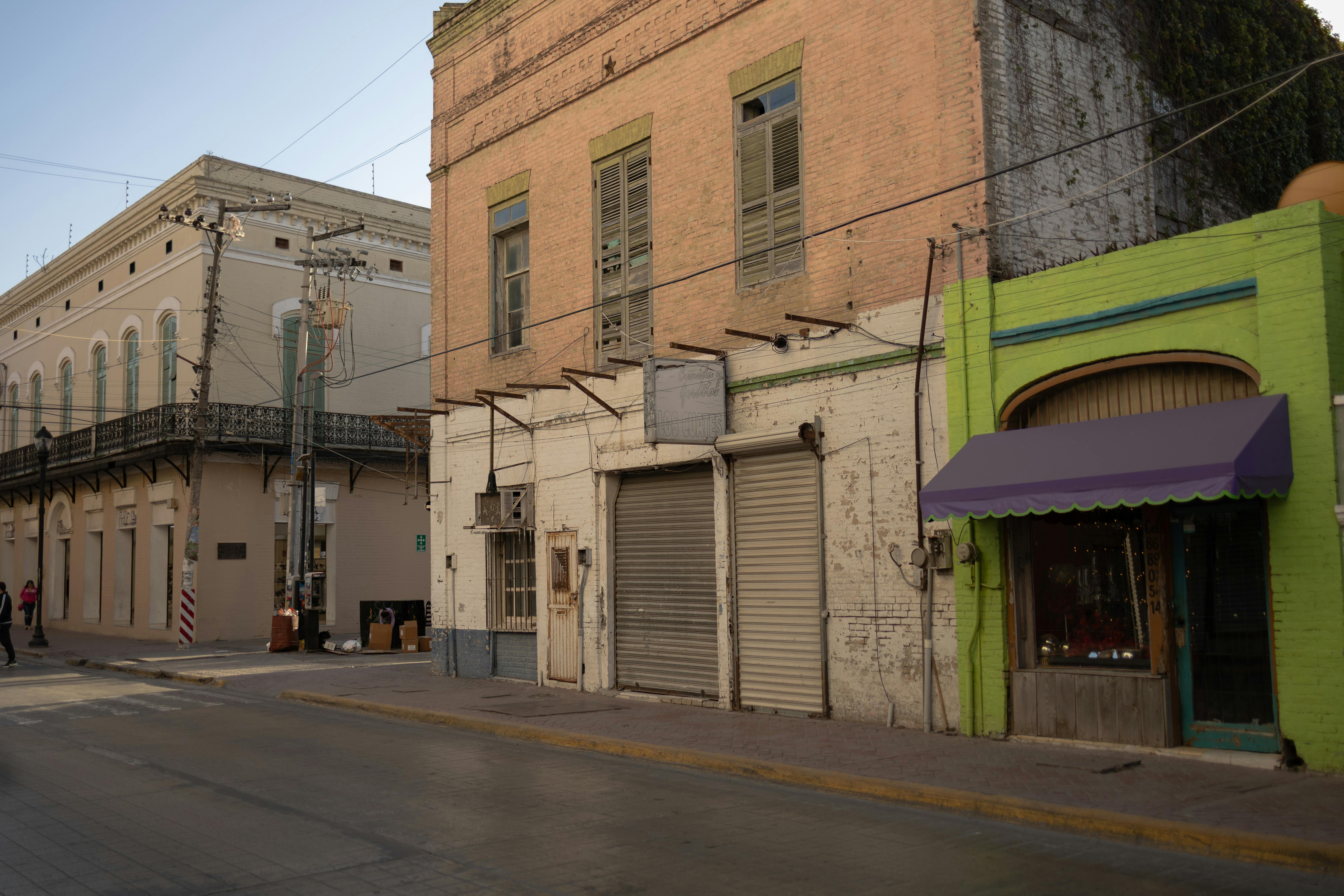 A peaceful street scene featuring colorful buildings in Heroica Matamoros, Mexico.
