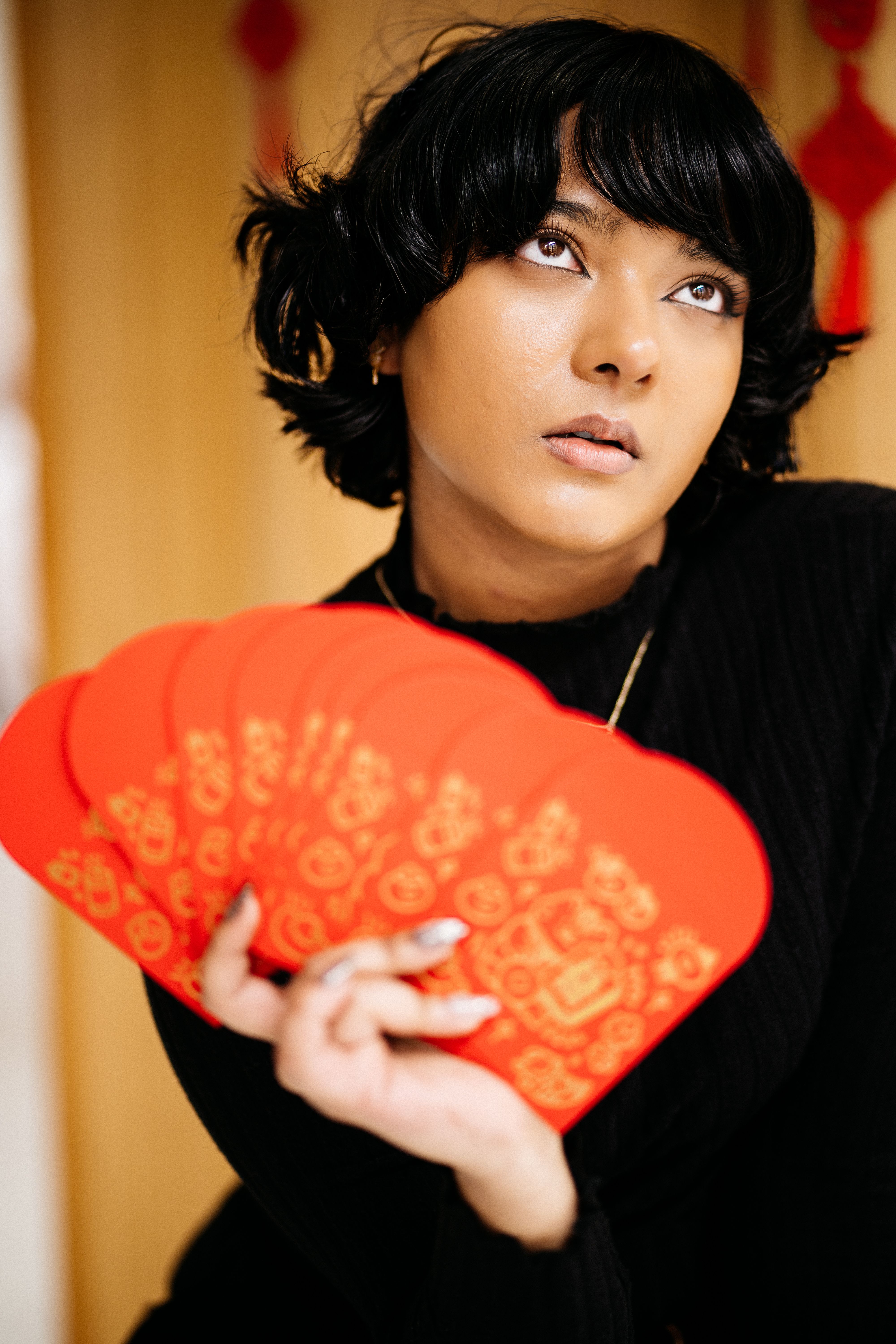Portrait of a woman holding red envelopes, symbolizing Lunar New Year traditions and prosperity.