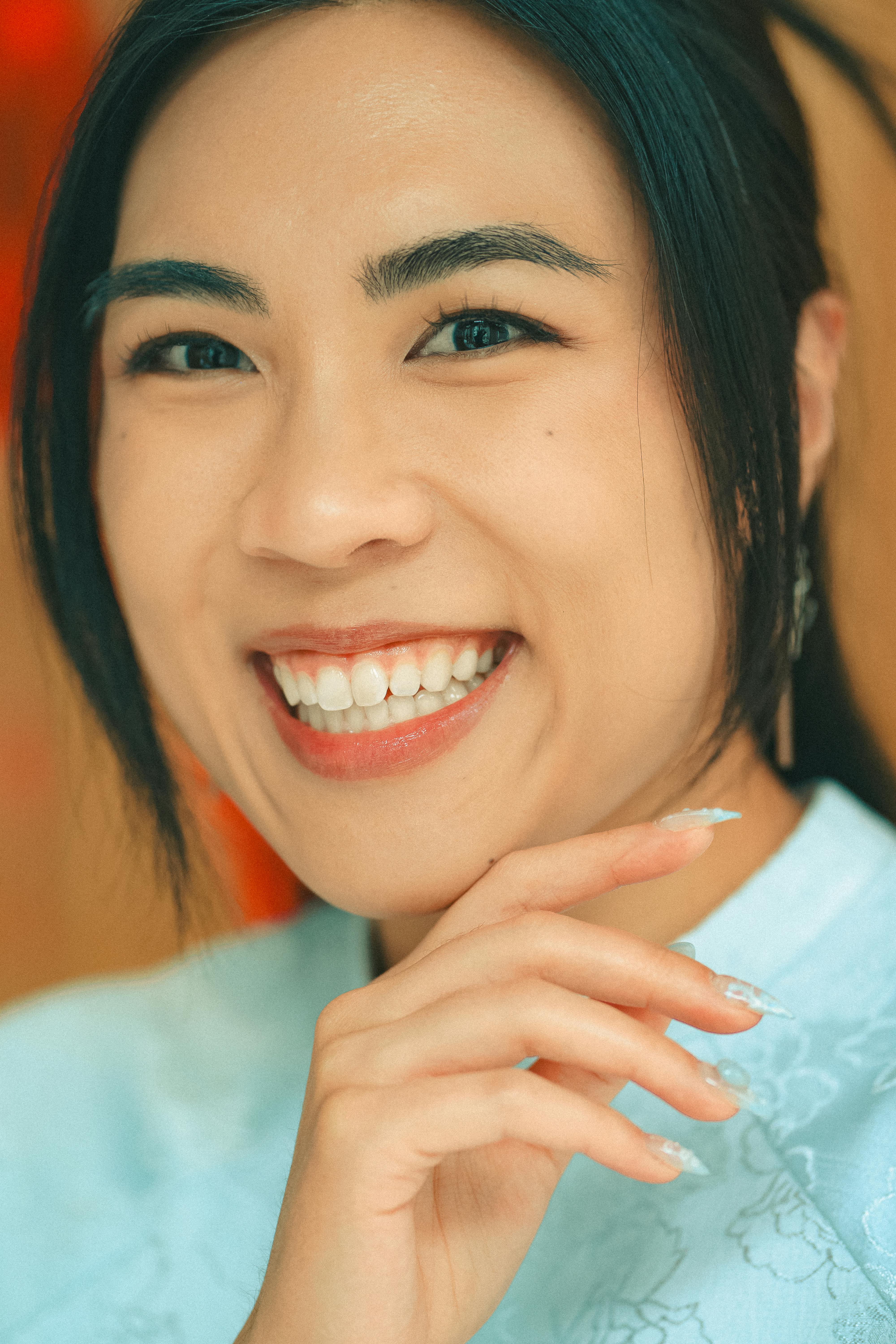 бесплатная Крупный план радостной азиатской женщины, улыбающейся во время новогоднего торжества в помещении. Стоковое фото