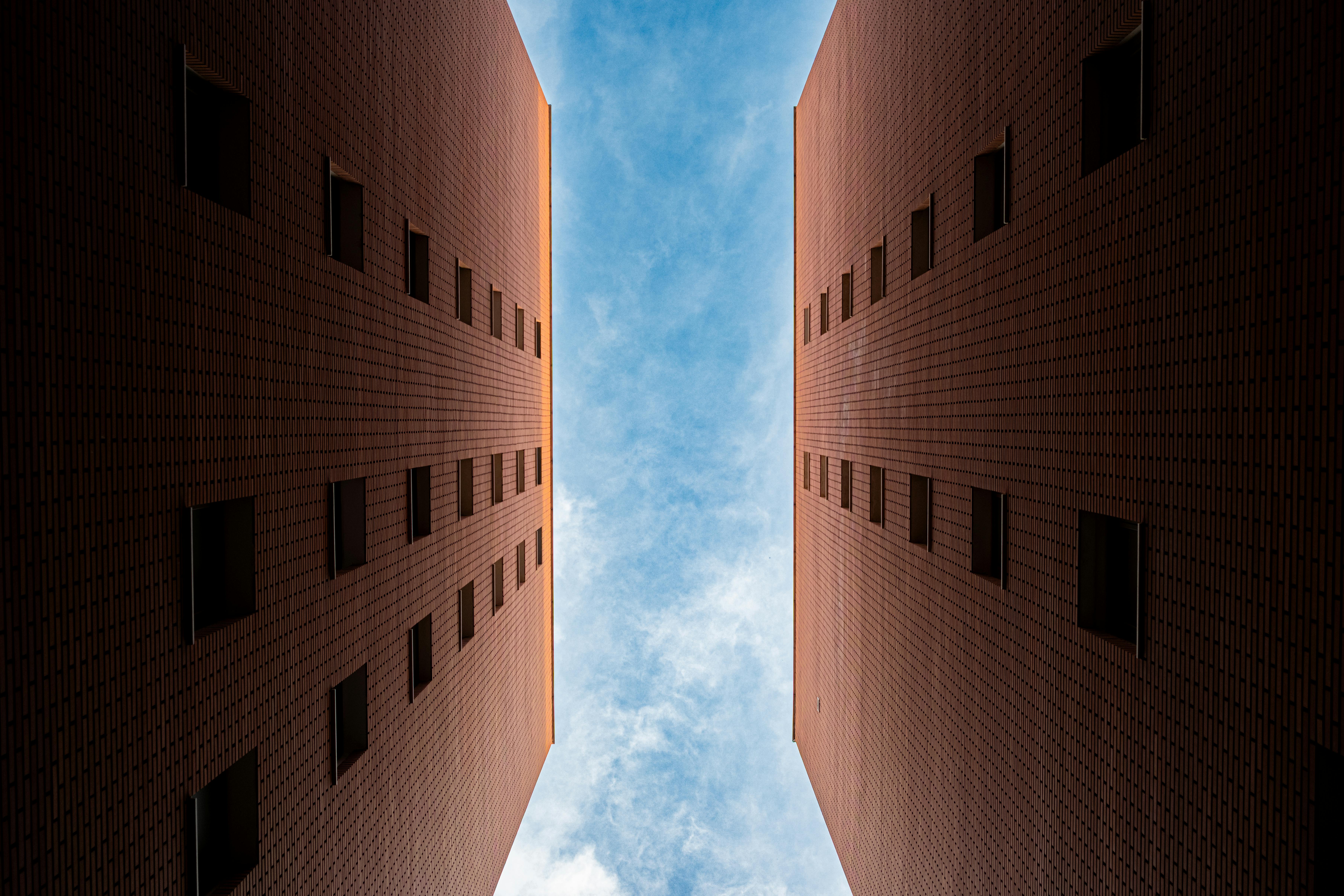 gratis In Tirana, Albanië, vormen gebouwen van rode baksteen een symmetrische corridor die naar een helderblauwe hemel leidt. Stockfoto