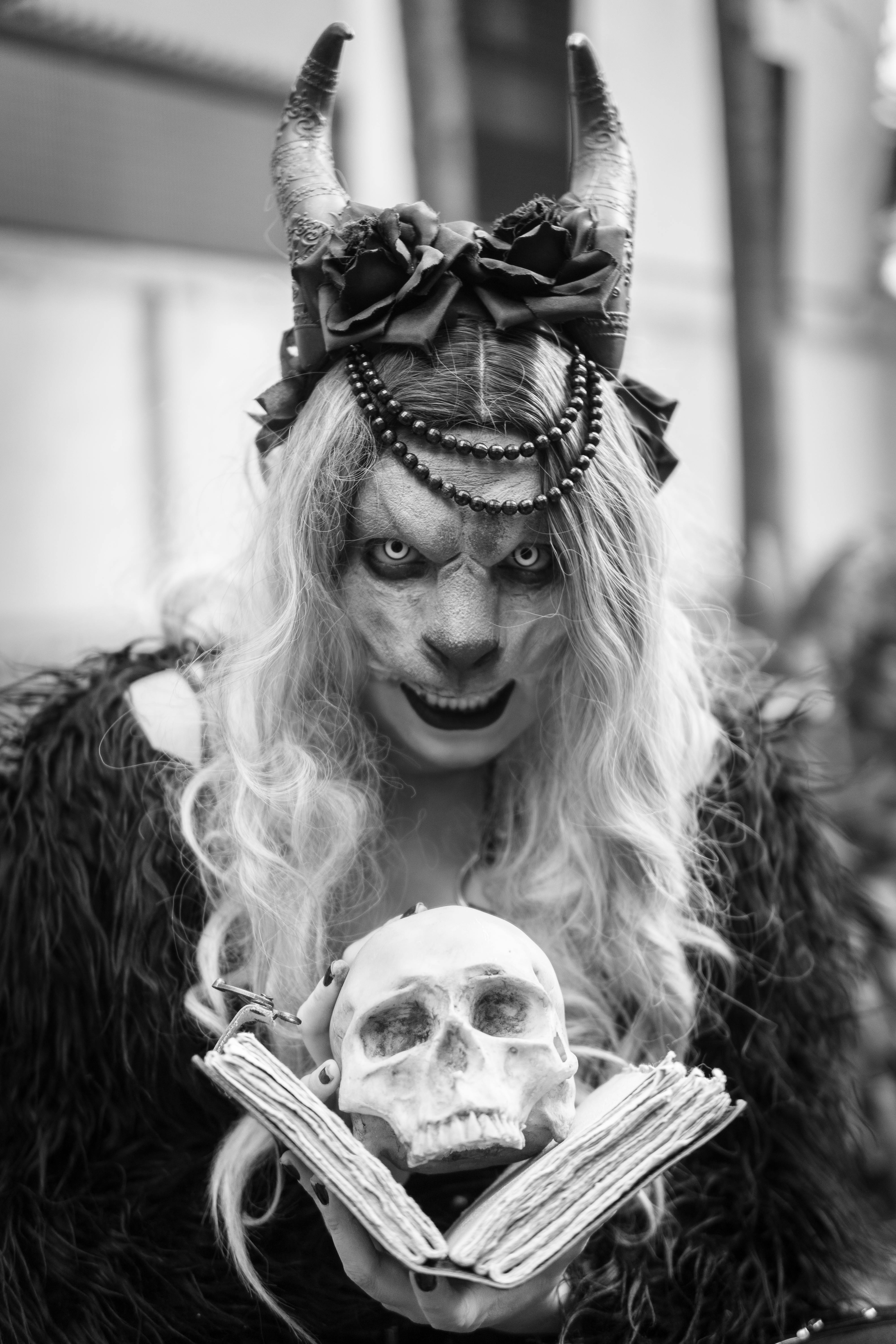 бесплатная Завораживающая мифическая фигура, держащая череп и книгу, воплощает фантазию и интригу. Стоковое фото