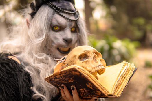 A mystical character holding a skull and spellbook in a forest setting.