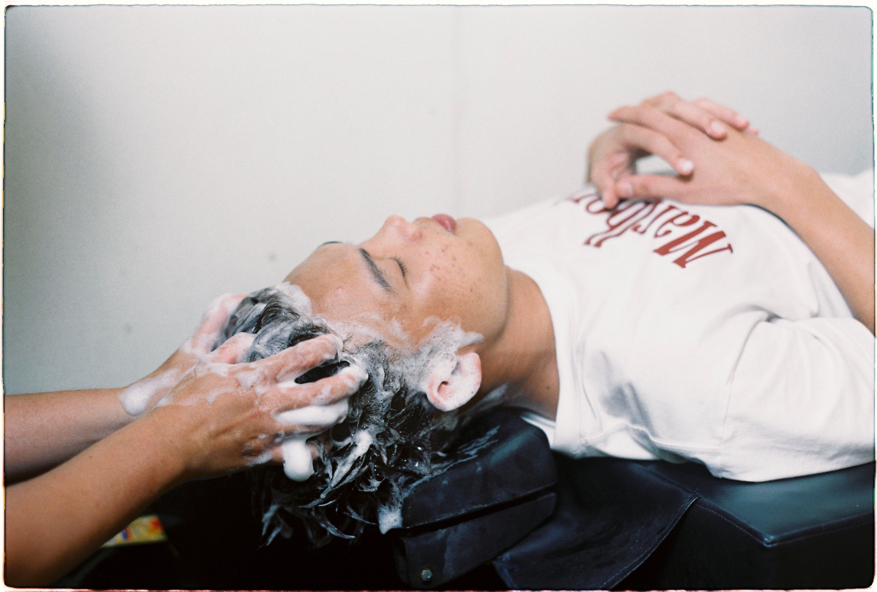A person enjoying a soothing hair wash in a salon setting, conveying relaxation.