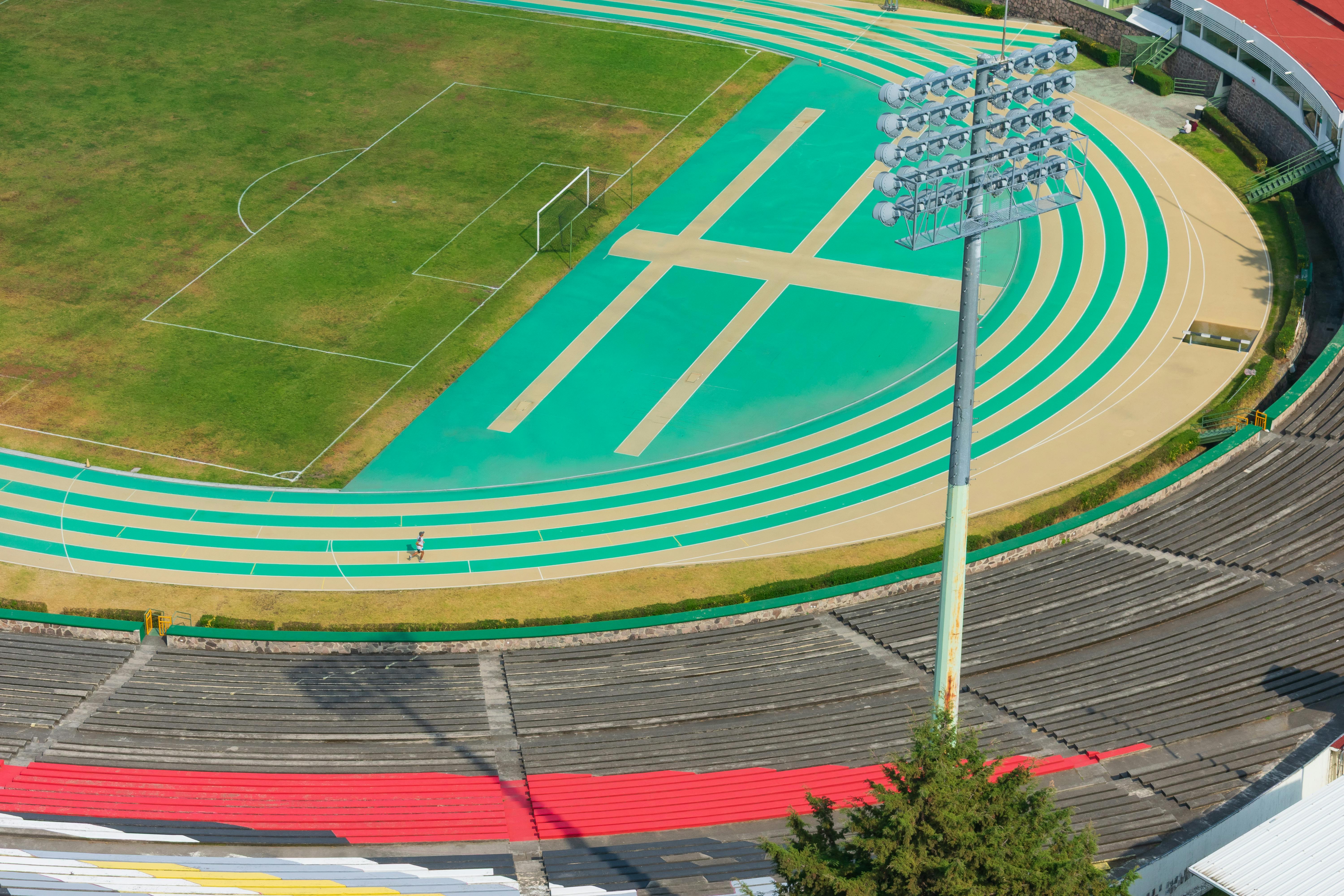 бесплатная Аэрофотоснимок открытой спортивной беговой дорожки и стадиона в Толука-де-Лердо, Мексика, запечатлевший яркие цвета и спортивный дизайн. Стоковое фото