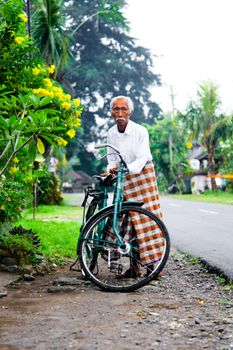 Senior man with traditional bicycle by the roadside in Penebel, Bali. - Fotografer Sidoarjo