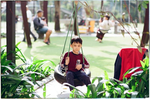 A child happily swings on a tire swing in a tranquil park environment, surrounded by greenery.