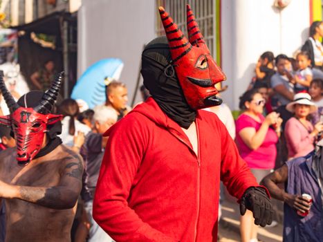 Men in traditional costumes participate in a colorful carnival in Tlapehuala, Puebla, Mexico.