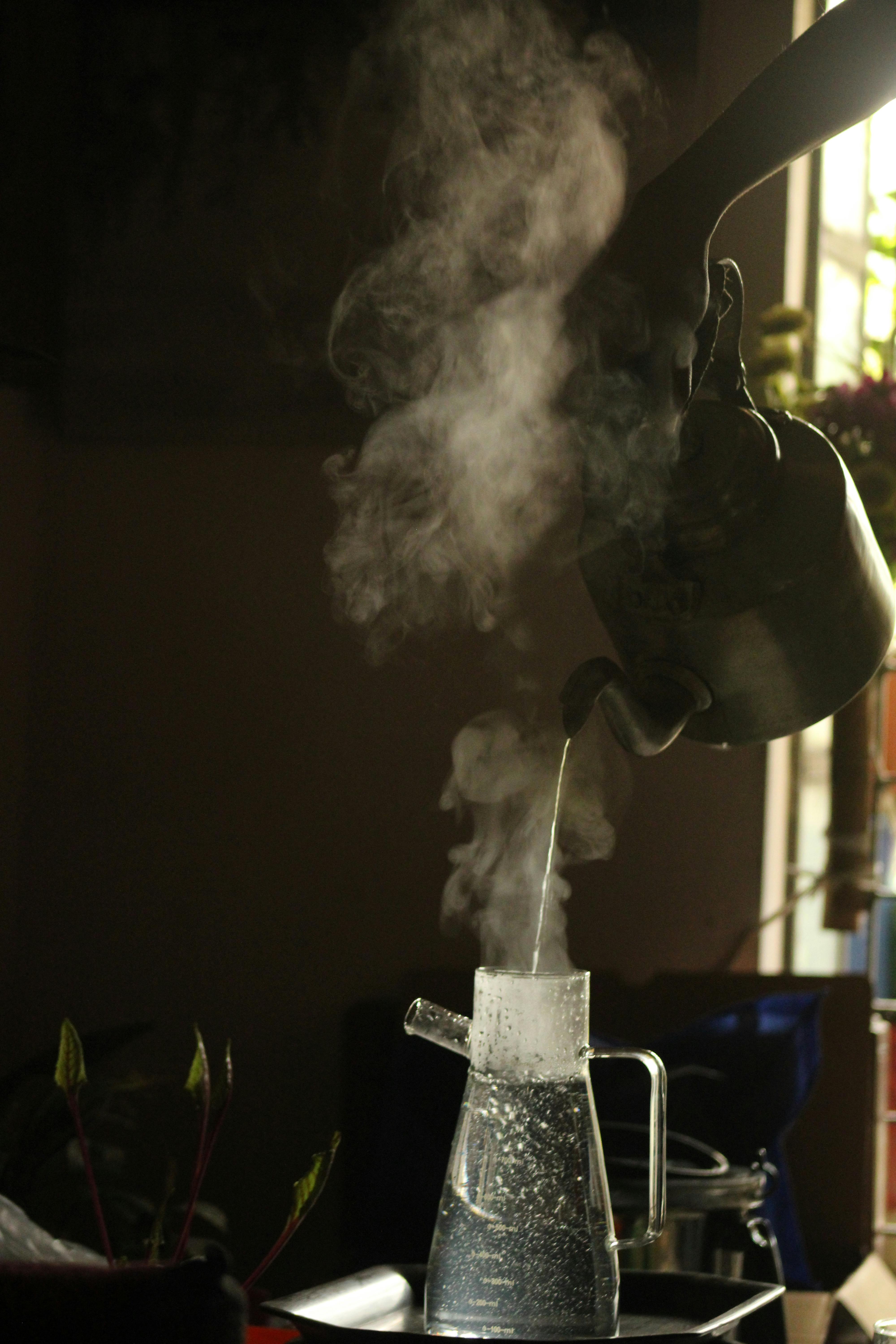 Gratis Gambar close-up sebuah ketel yang menuangkan air panas ke dalam kendi kaca di dalam ruangan. Foto Stok