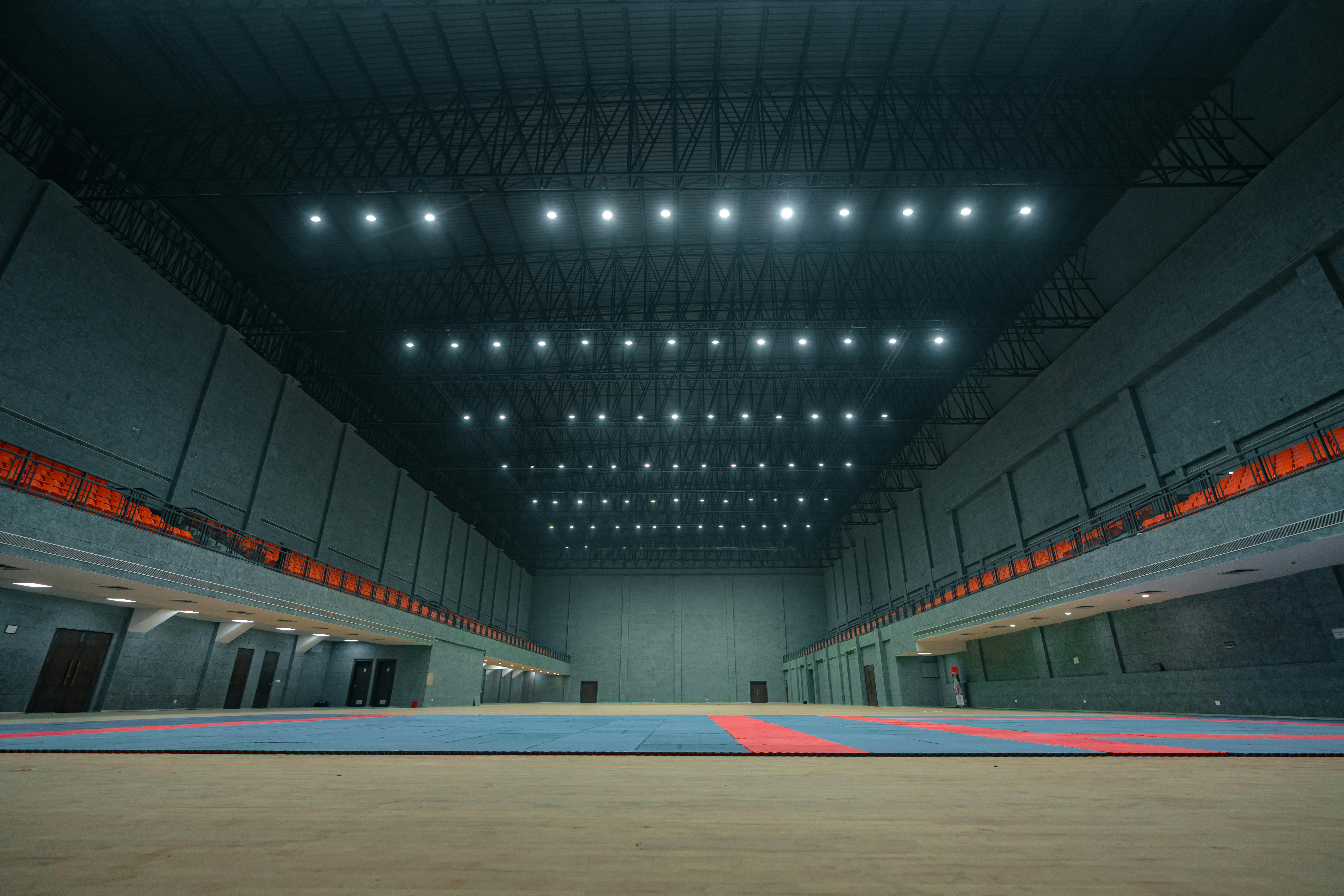 бесплатная Просторный крытый спортивный зал с ярким потолочным освещением и свободным полом в Сурате, Индия. Стоковое фото