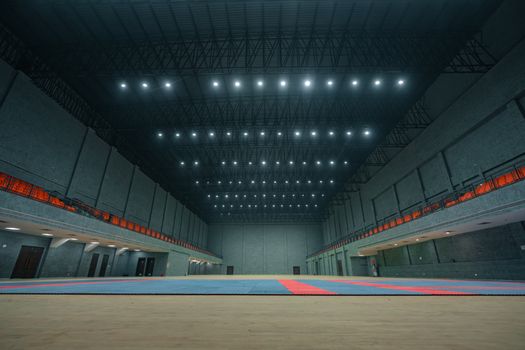Spacious indoor sports hall with bright ceiling lights and empty flooring in Surat, India.