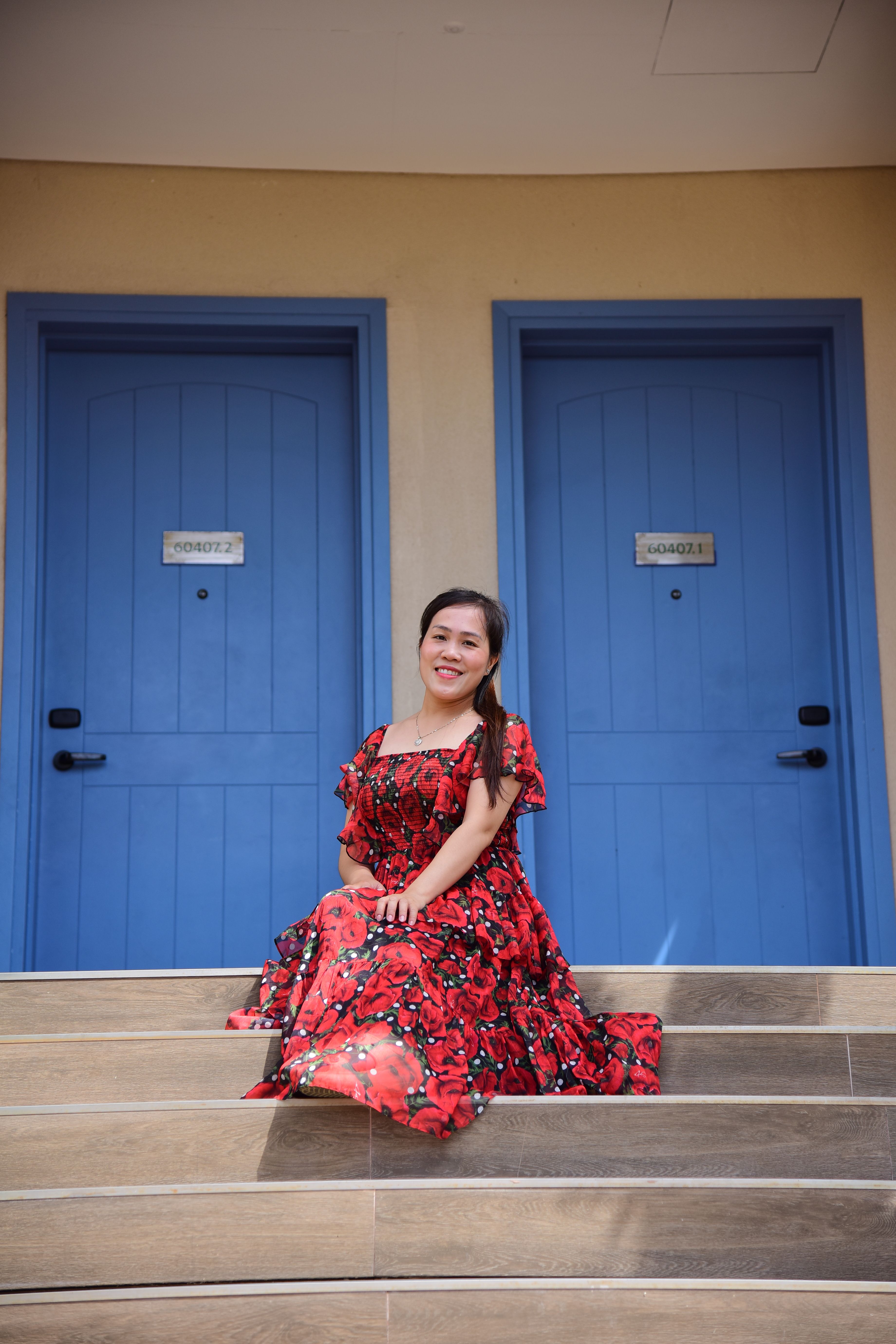 Woman in Red Floral Dress Sitting on Steps · Free Stock Photo