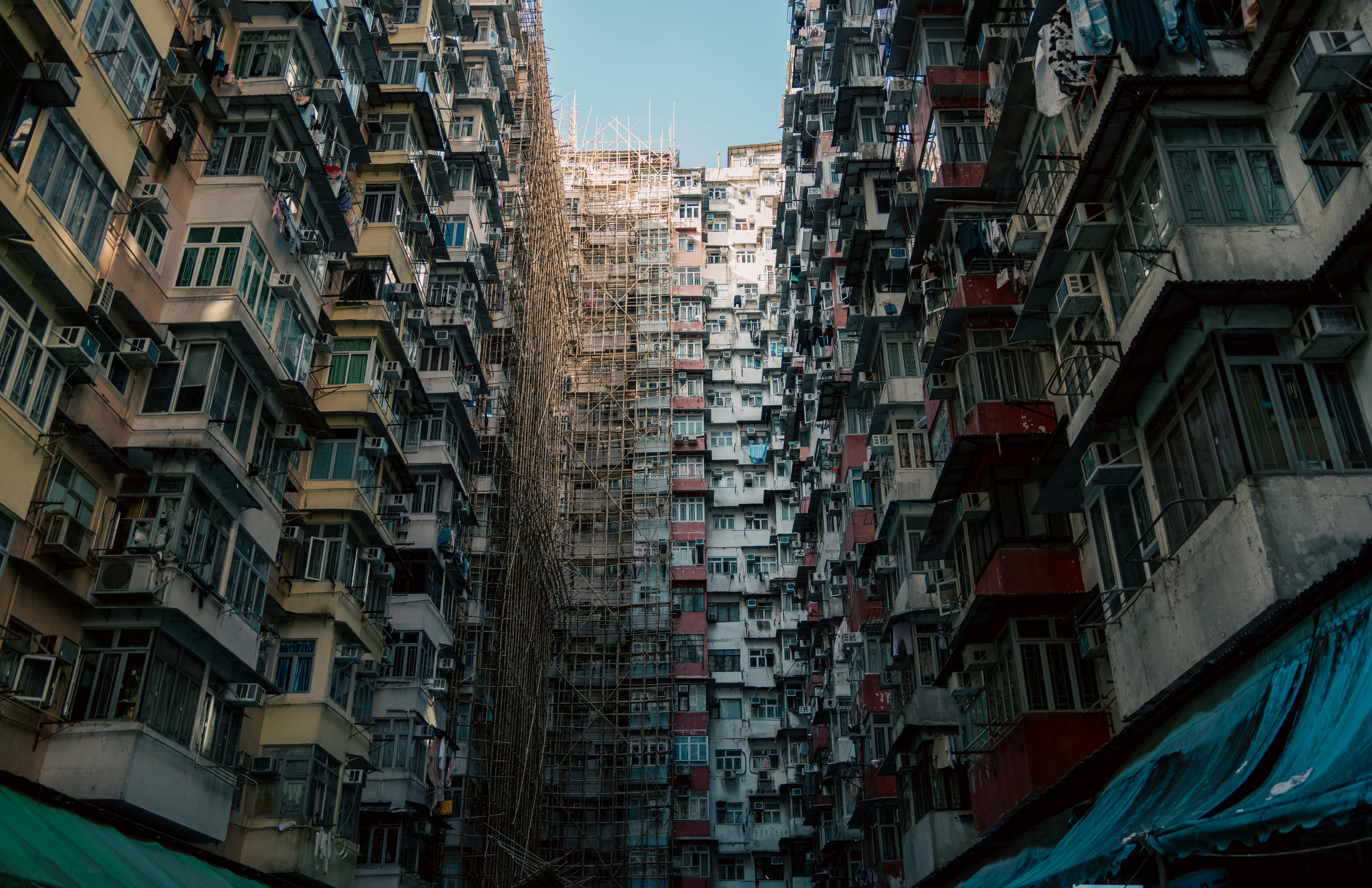 無料 混雑した都市環境の中に、足場が組まれた密集した都市型アパート群。 写真素材