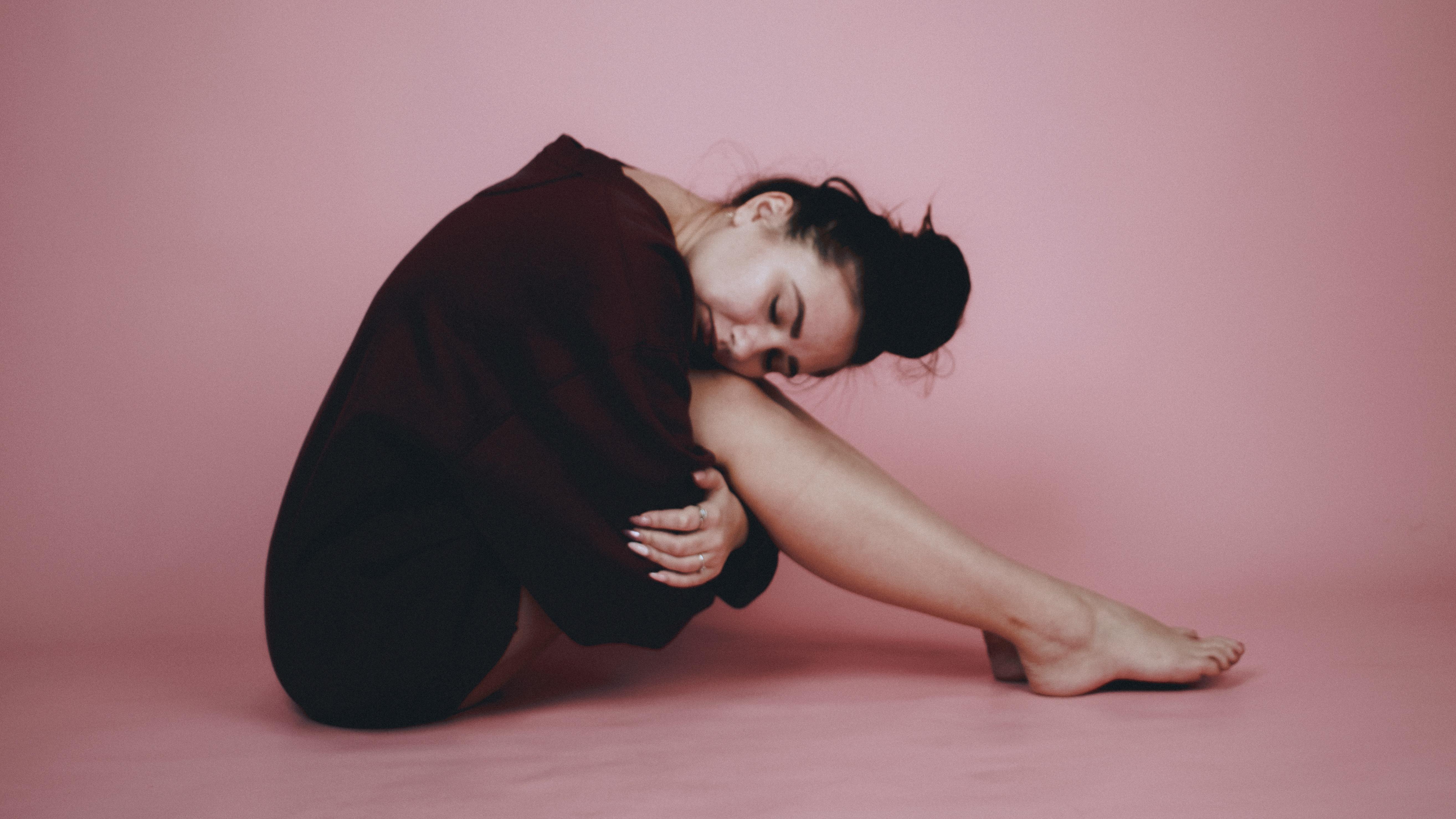 ADHD emotional dysregulation emotional regulation adhd symptoms — woman sitting floor back against wall holding knees soft natural light
