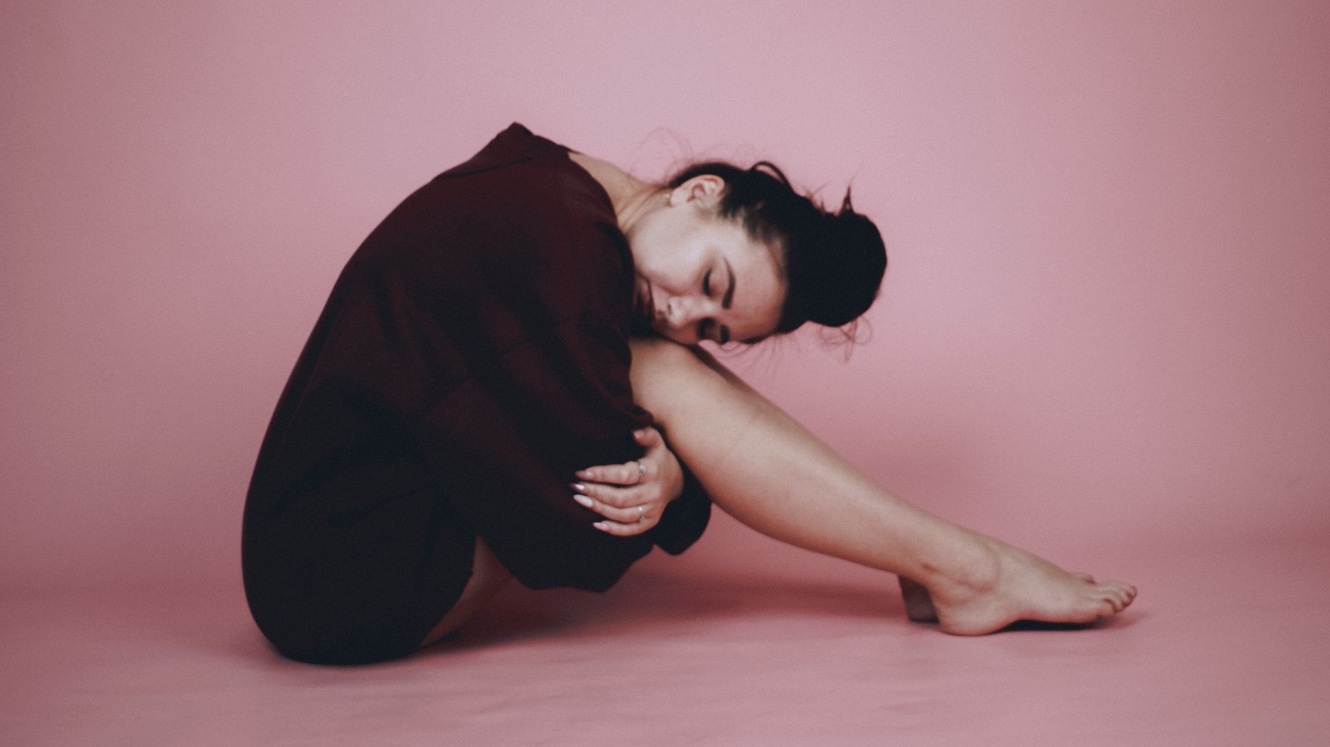 ADHD emotional dysregulation emotional regulation adhd symptoms — woman sitting floor back against wall holding knees soft natural light