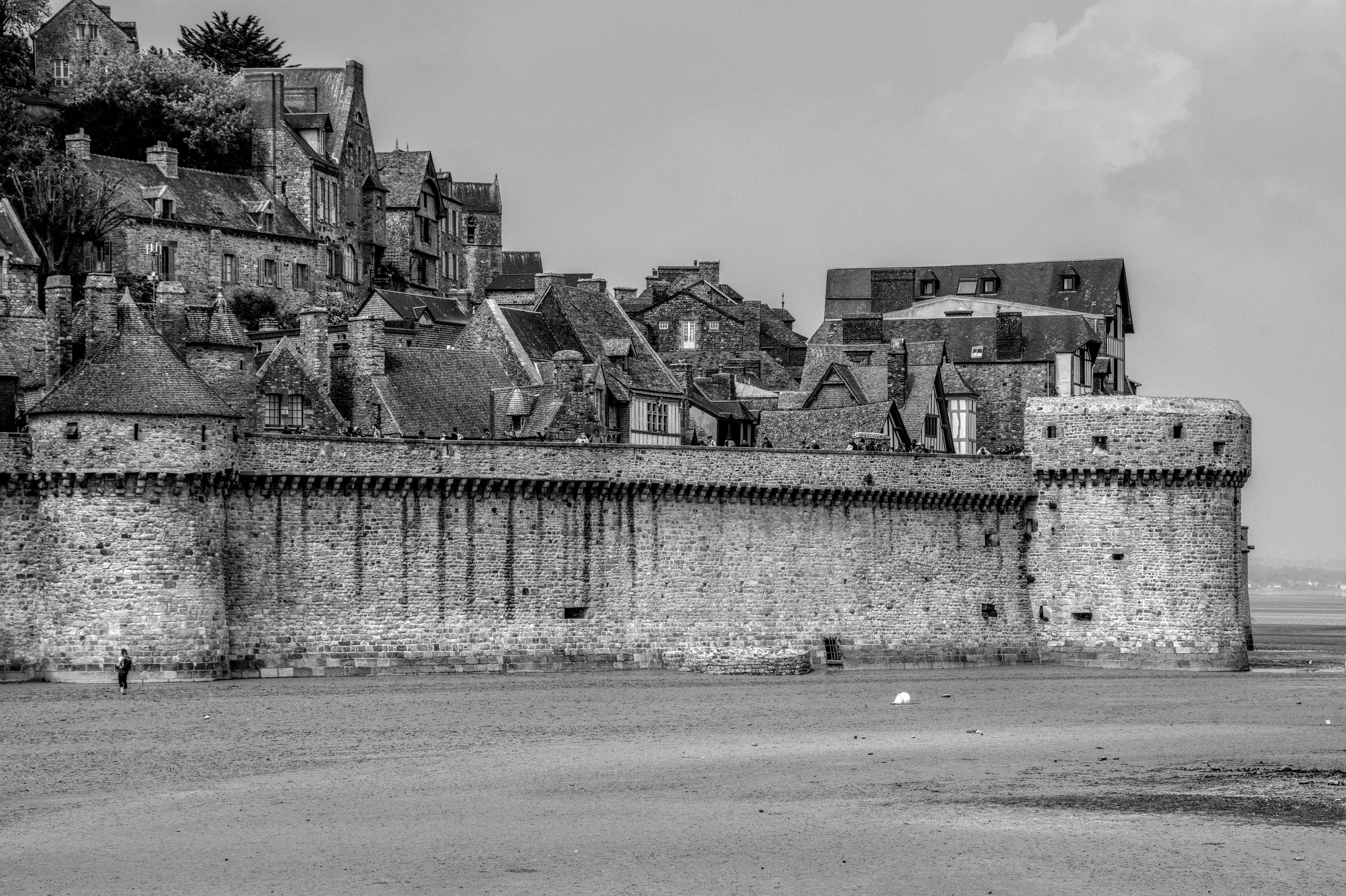 бесплатная На этой черно-белой фотографии вы сможете полюбоваться исторической каменной архитектурой средневековых стен Сен-Мало. Стоковое фото