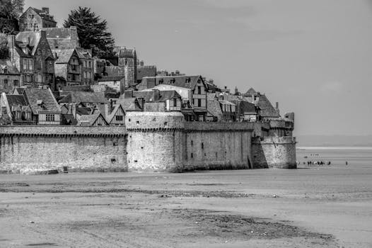 Black and white view of Mont Saint-Michel in France, highlighting its medieval architecture.