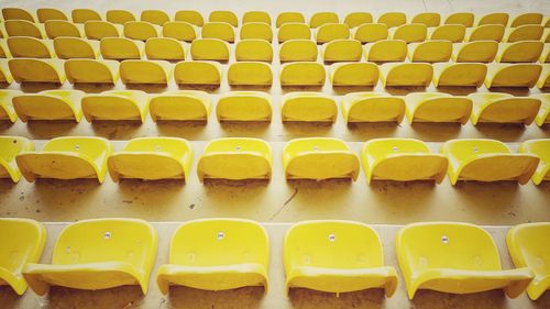 Free Empty yellow stadium seats arranged in rows, creating a vibrant and geometric pattern. Stock Photo