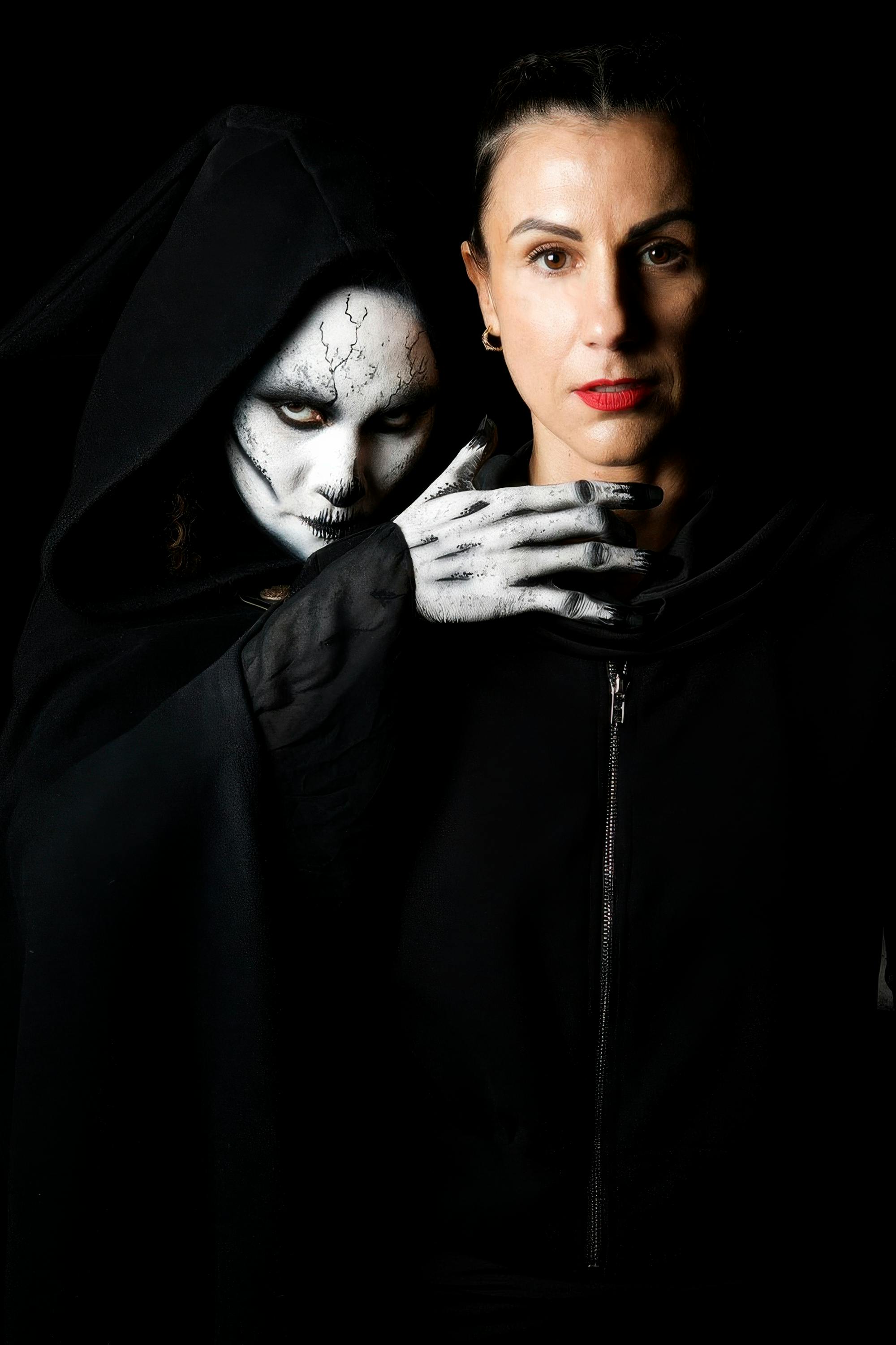 Gratis Potret studio yang mencekam dari seorang wanita dengan sosok malaikat maut berjubah hitam di bawah pencahayaan dramatis. Foto Stok