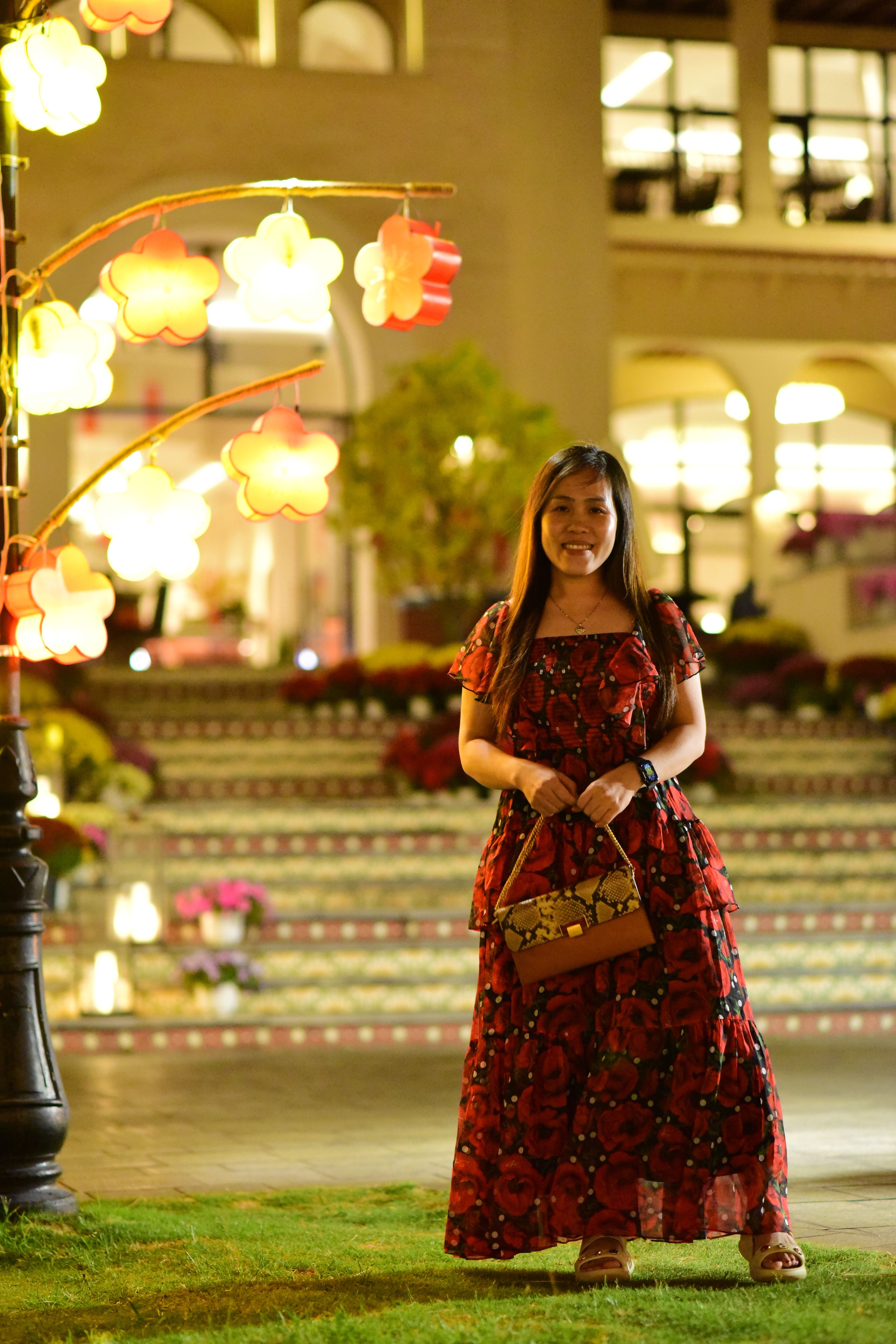 Woman in red floral dress at illuminated outdoor venue · Free Stock Photo