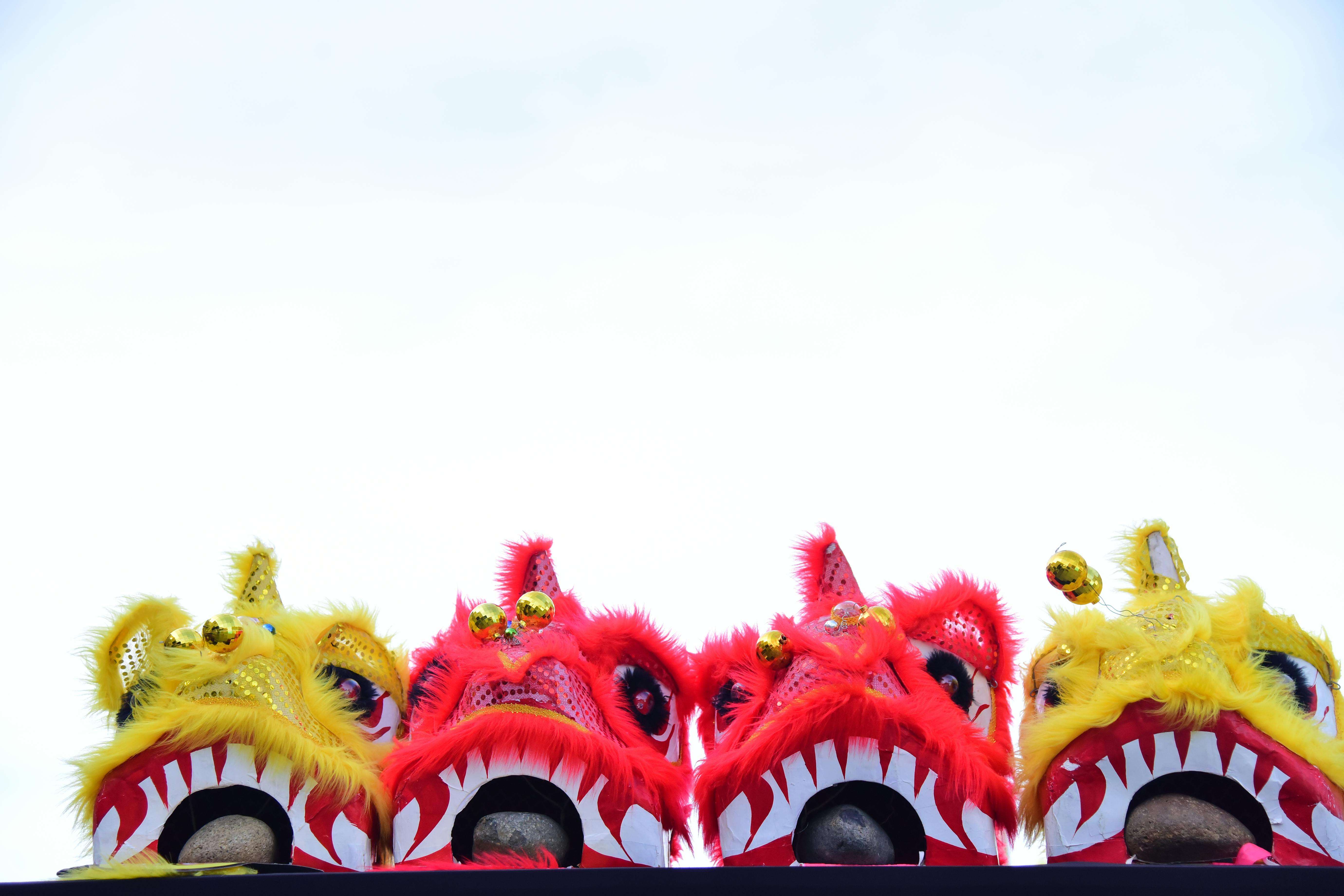 Ilmainen Värikkäitä kiinalaisia ​​leijonatanssipukuja kirkkaan taivaan taustalla. Kuvapankkikuva