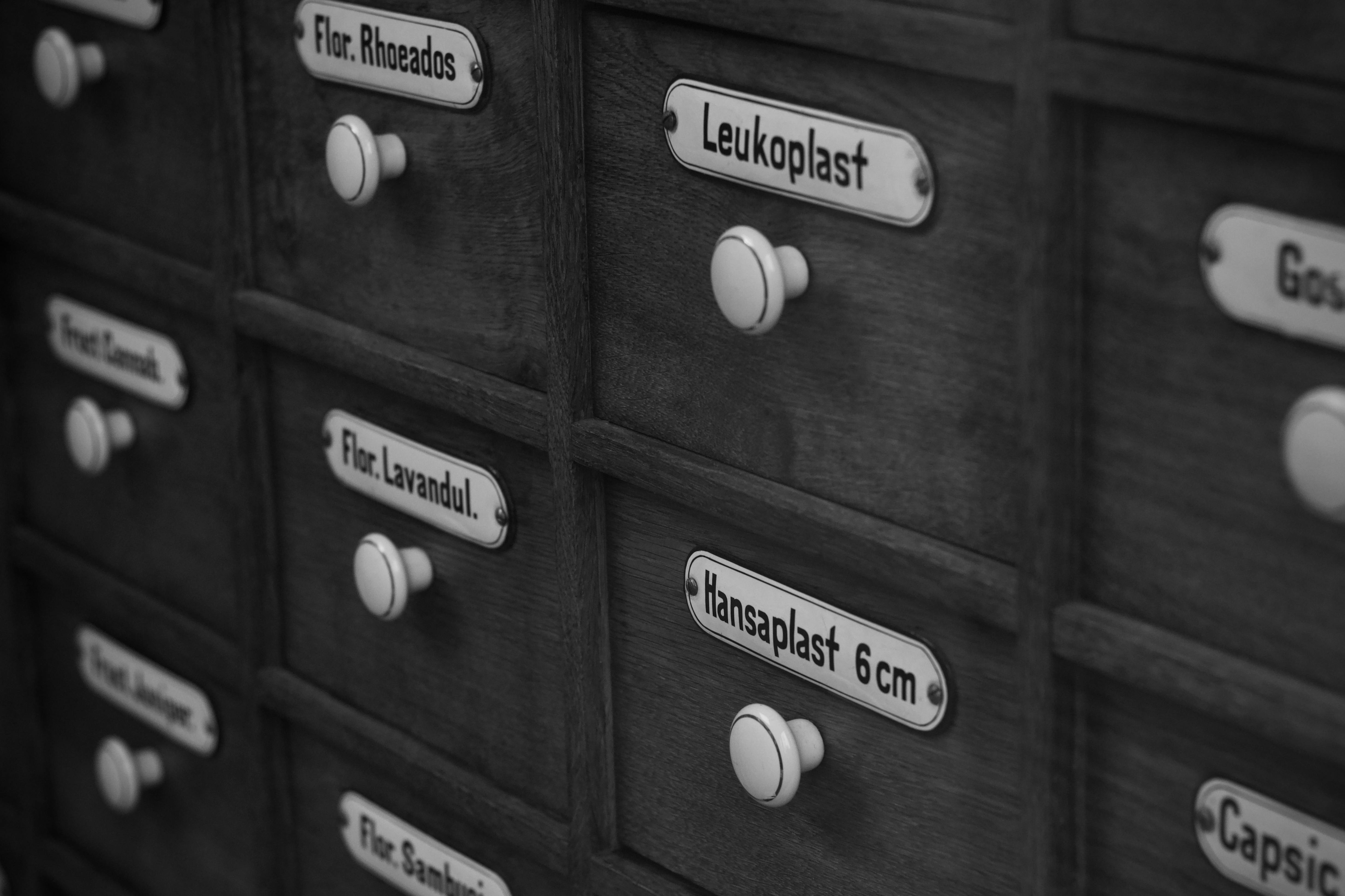 бесплатная Винтажный аптекарский шкаф с ящиками, на которых указаны медицинские термины, такие как Leukoplast и Hansaplast 6cm. Стоковое фото