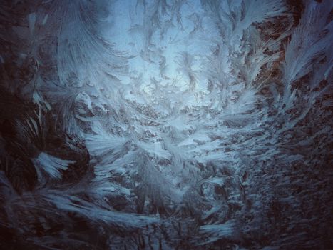 Detailed close-up of beautiful frost patterns on a window, showcasing nature's artistic touch.