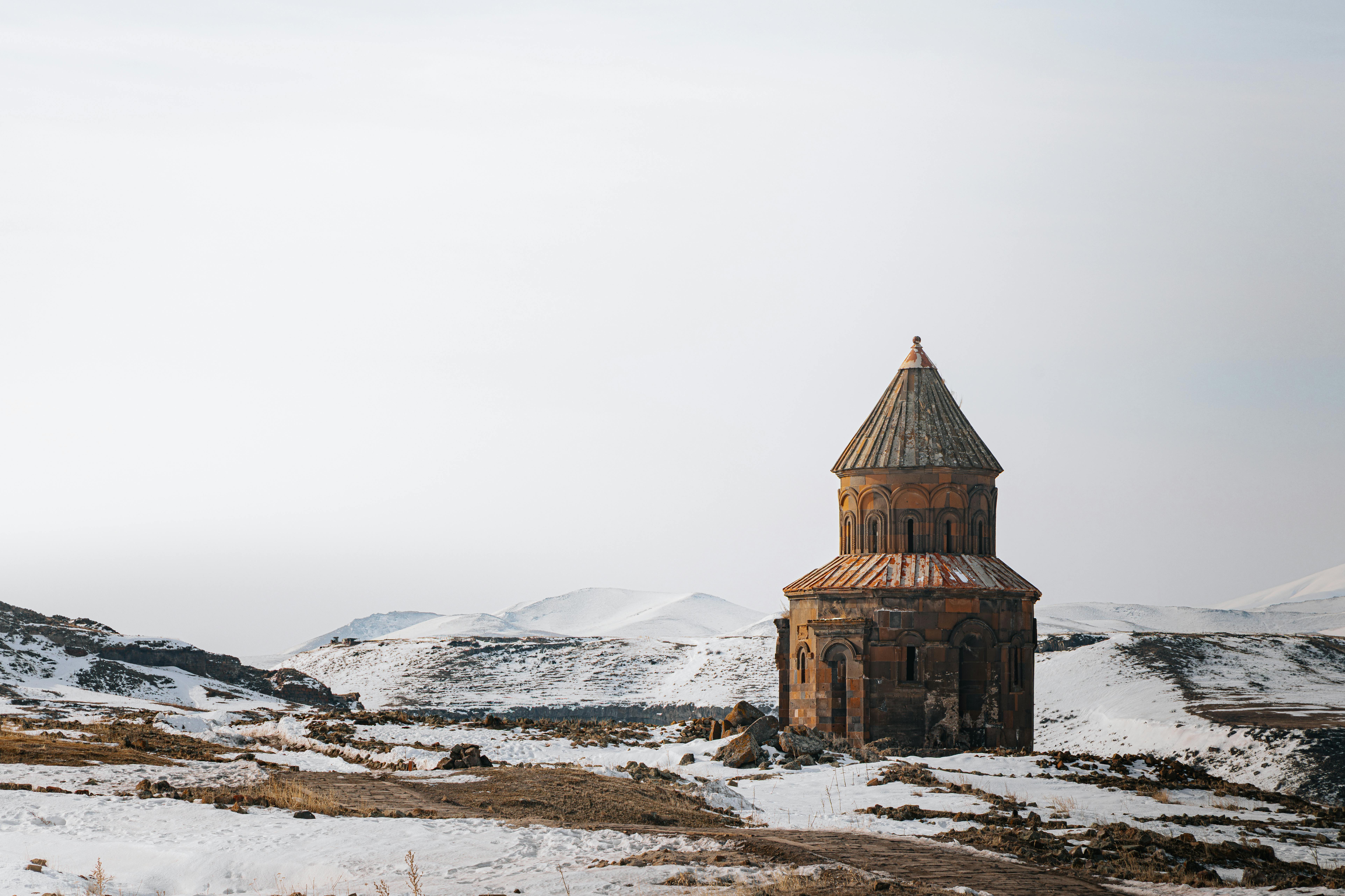 Gratis Pemandangan indah sebuah gereja bersejarah di Kars, Turki, yang diselimuti salju. Foto Stok