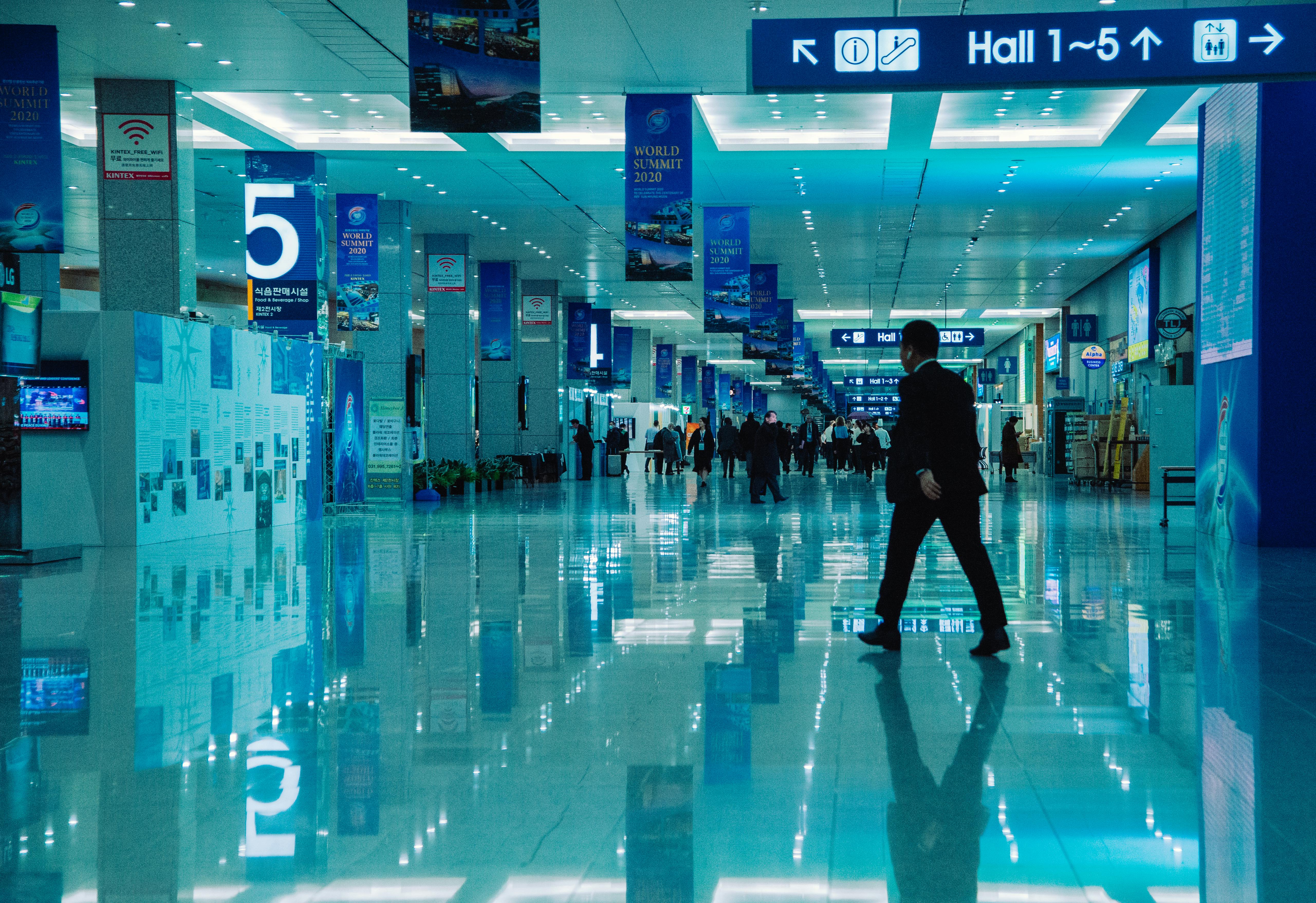 бесплатная Вид изнутри оживленного конференц-зала во время Всемирного саммита 2020 года с указателями и отражениями. Стоковое фото