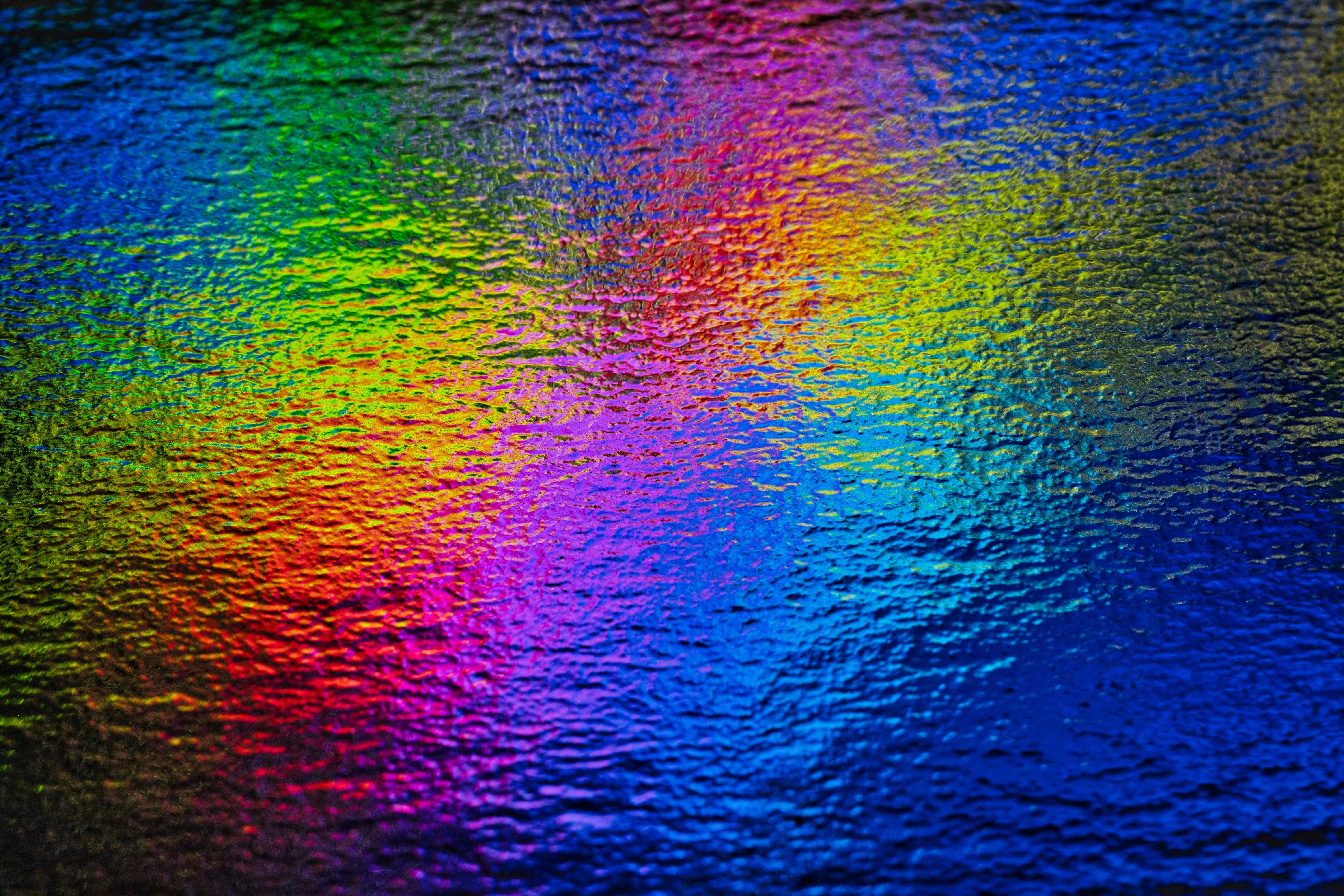 бесплатная Яркая и красочная абстрактная текстура с радужными оттенками и волнистой поверхностью. Стоковое фото