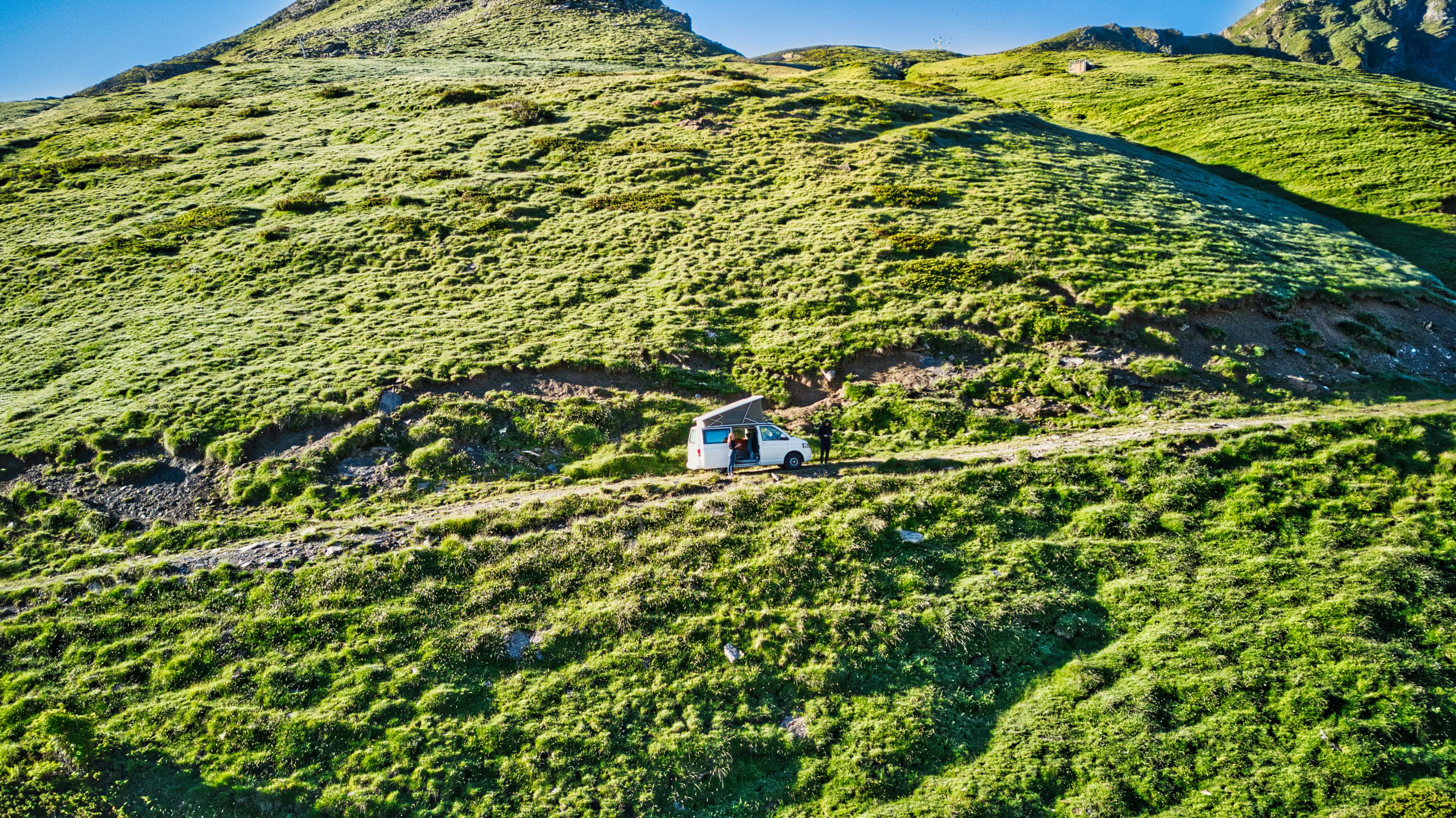 grátis Experimente a liberdade da vida em uma van percorrendo estradas panorâmicas nas montanhas, perfeitas para amantes da natureza e aventureiros. Foto profissional