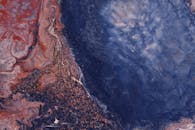 这幅动态抽象画以深蓝色和充满活力的红色漩涡为特色，并点缀着金色的笔触