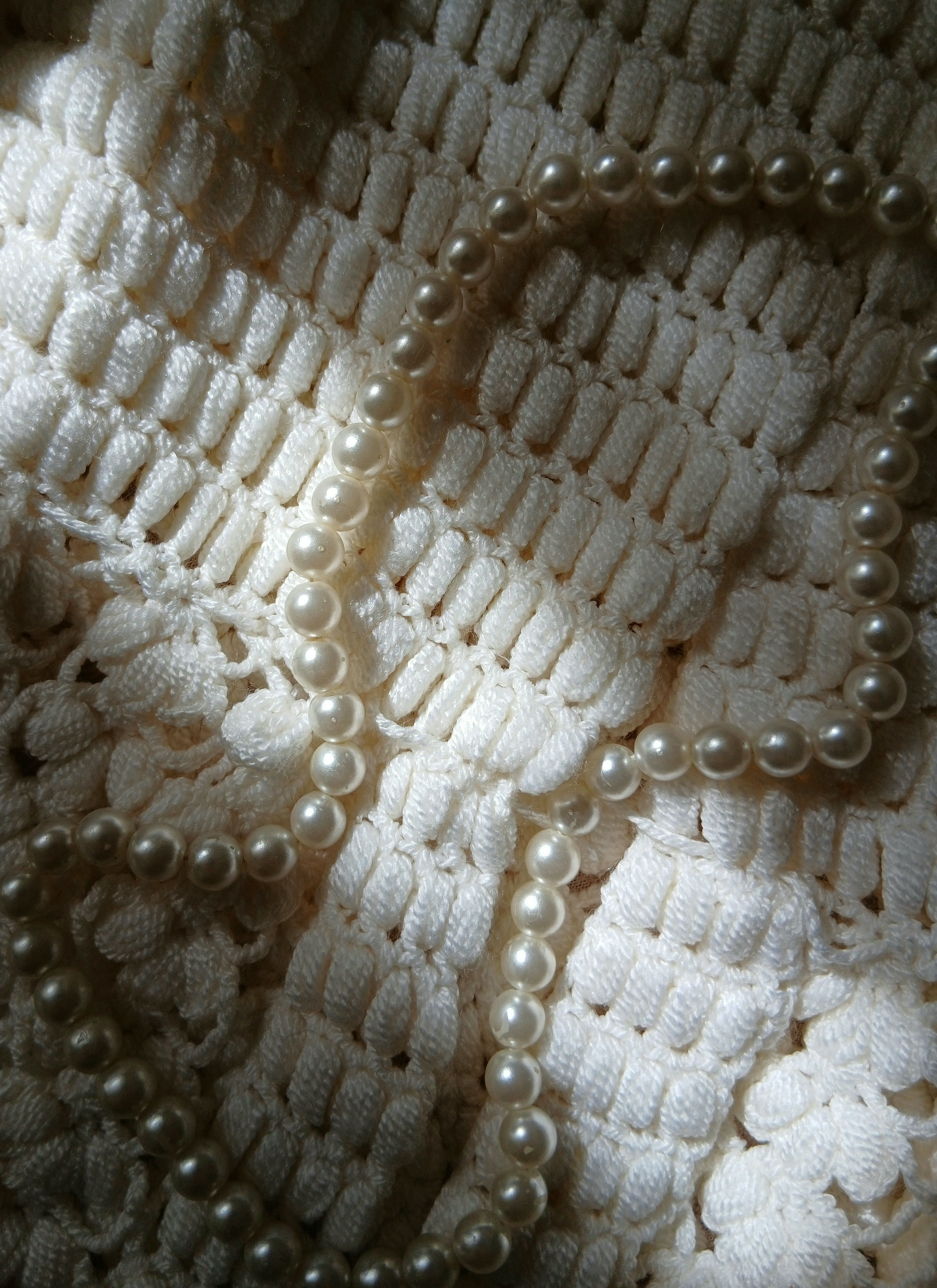 Elegant Pearls on Crochet Fabric in Soft Light · Free Stock Photo