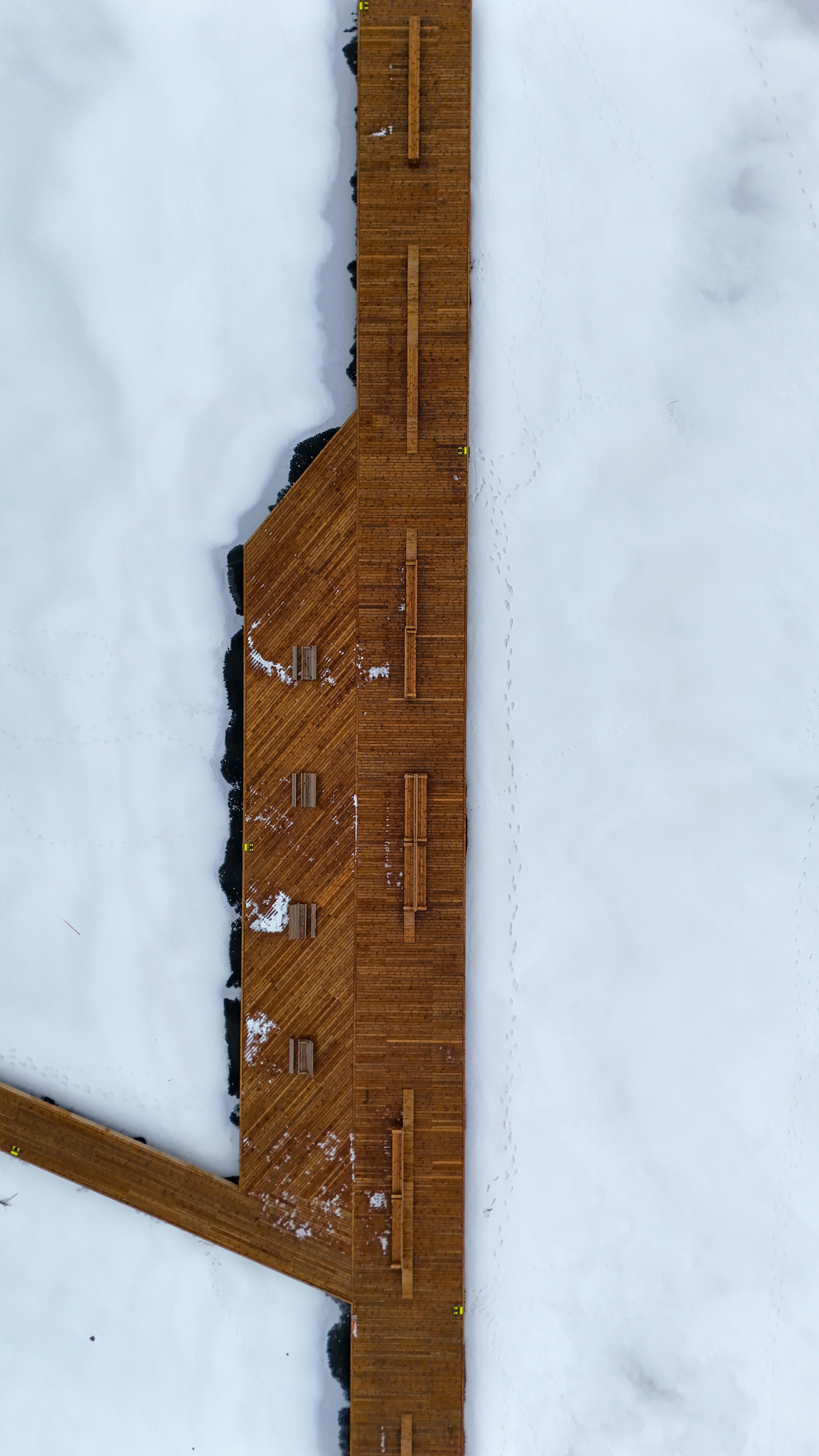 無料 スウェーデンのヨンショーピングにある雪景色を切り抜ける木製の小道を空中から撮影した写真。 写真素材