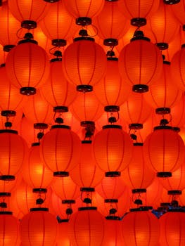 Colorful red lanterns create a warm, vibrant atmosphere in a traditional Japanese setting at night.